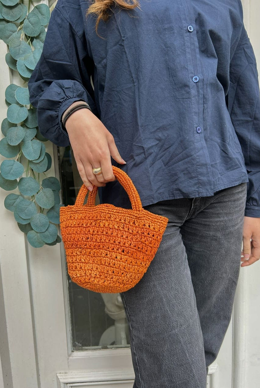 Détail du tressage en raphia du petit panier orange