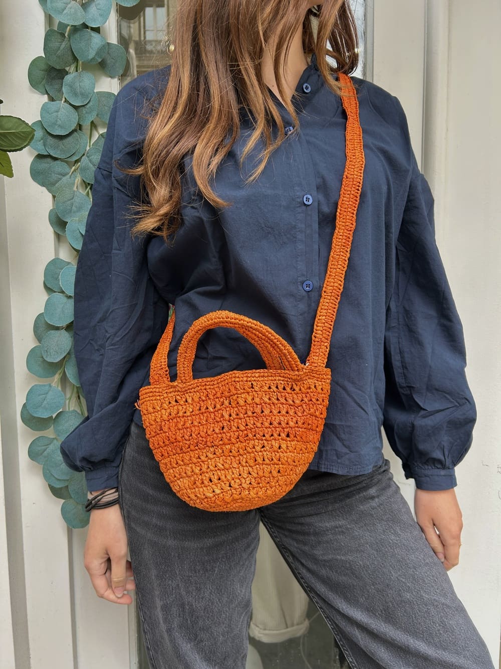 Femme portant le petit panier orange – Look estival et coloré