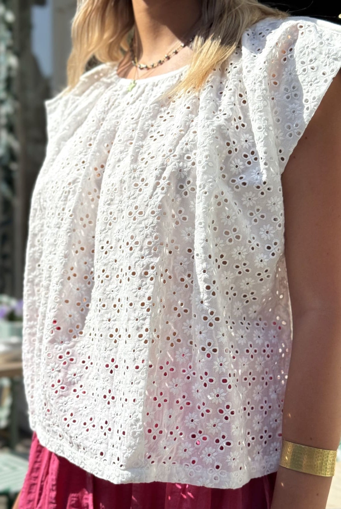Vue de profil de la blouse en broderie anglaise sans manche