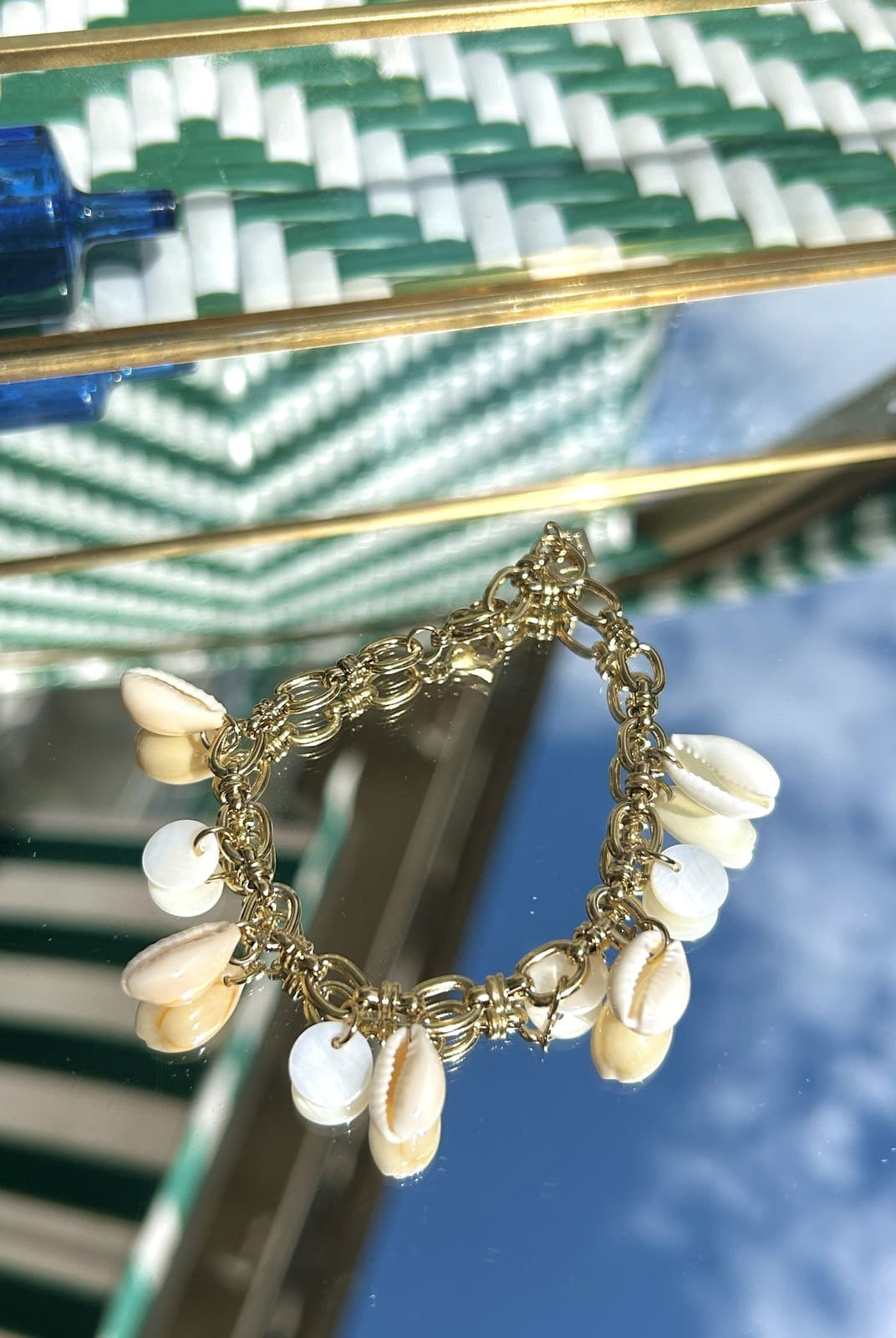 Bracelet breloque avec petits coquillages blancs sur chaîne dorée