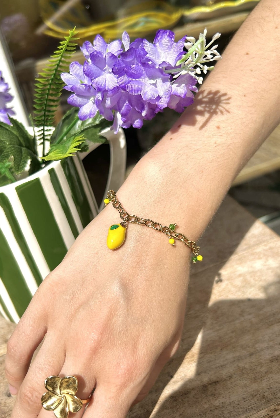 Bracelet breloque citron porté au poignet d’une femme