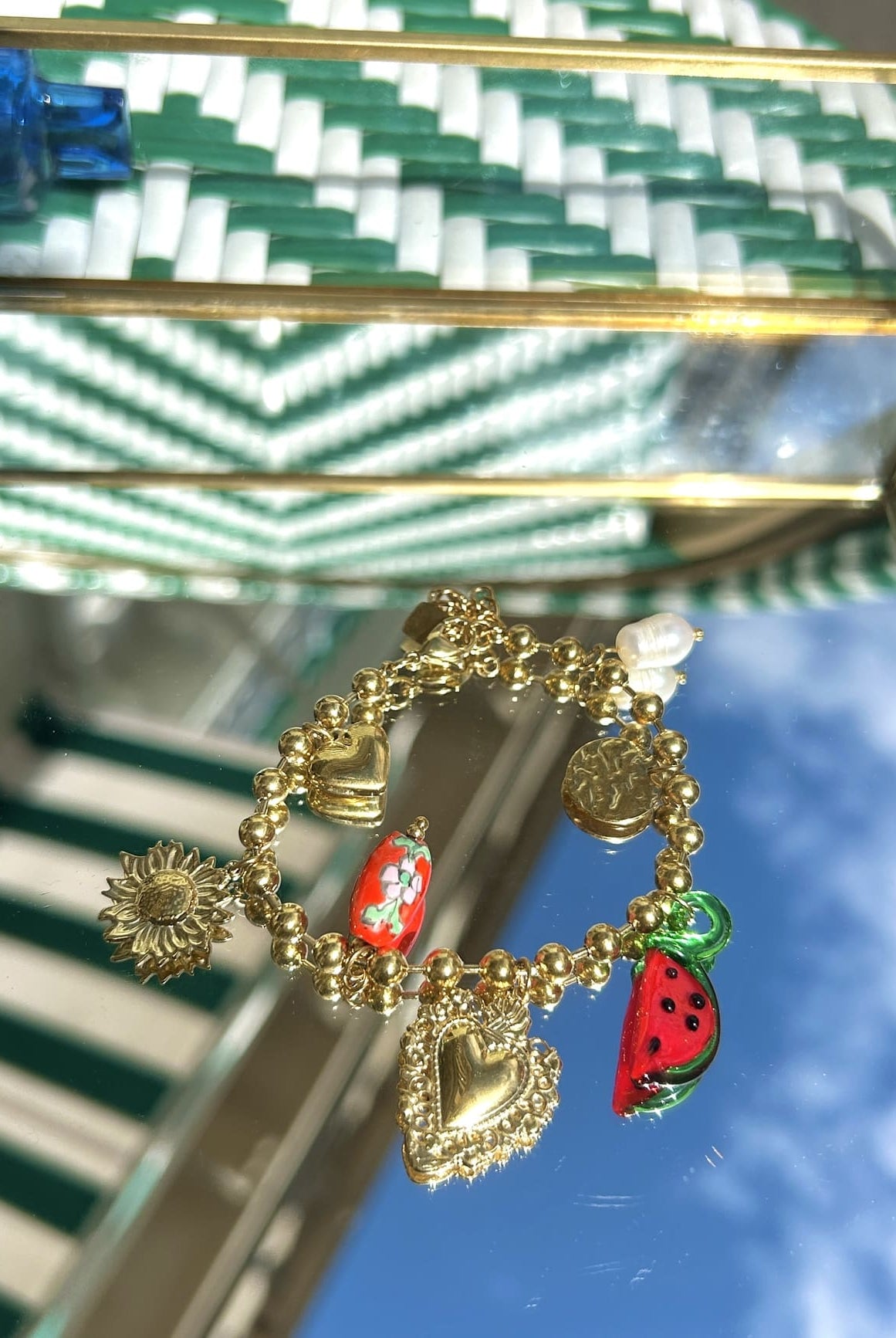 Bracelet breloque pastèque Ringo avec chaîne dorée, exposé sur fond clair