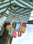 Bracelet coquillage avec perles blanches, posé sur fond clair