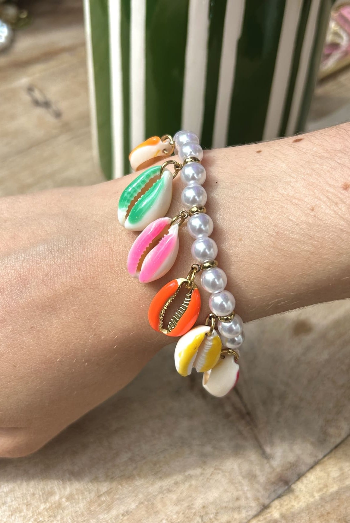 Femme portant un bracelet coquillage avec perles blanches au poignet