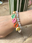 Femme portant un bracelet coquillage avec perles blanches au poignet