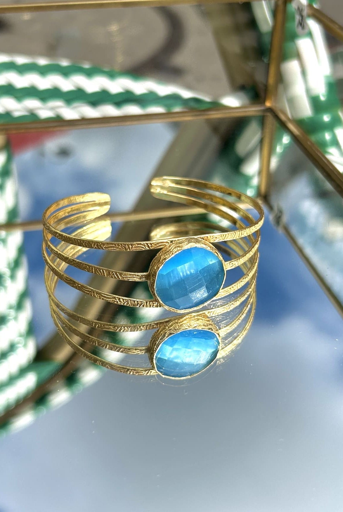 Détail du bracelet en laiton avec arcs élégants et pierre bleue semi-précieuse