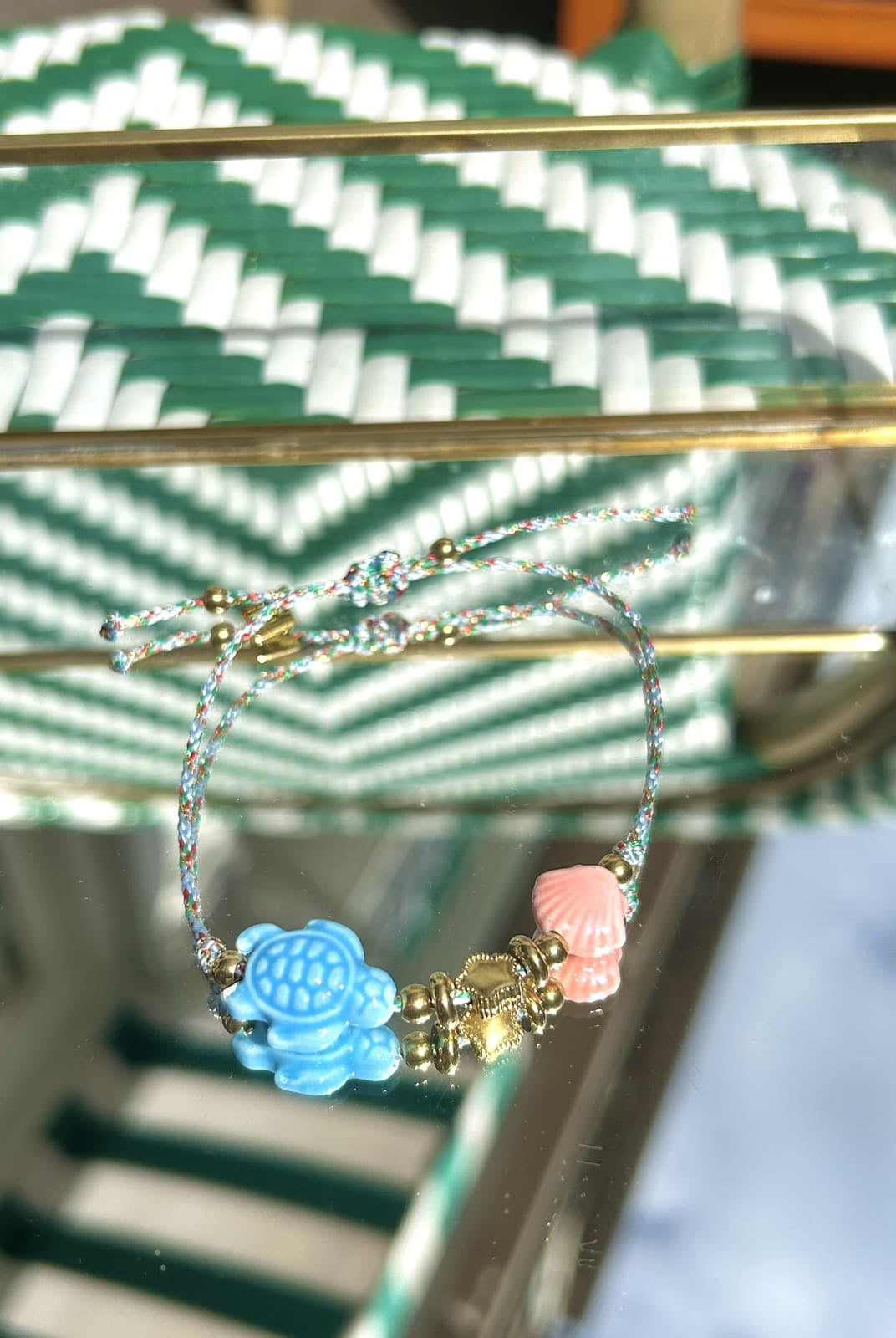 Gros plan sur la breloque tortue bleue et le cordon du bracelet