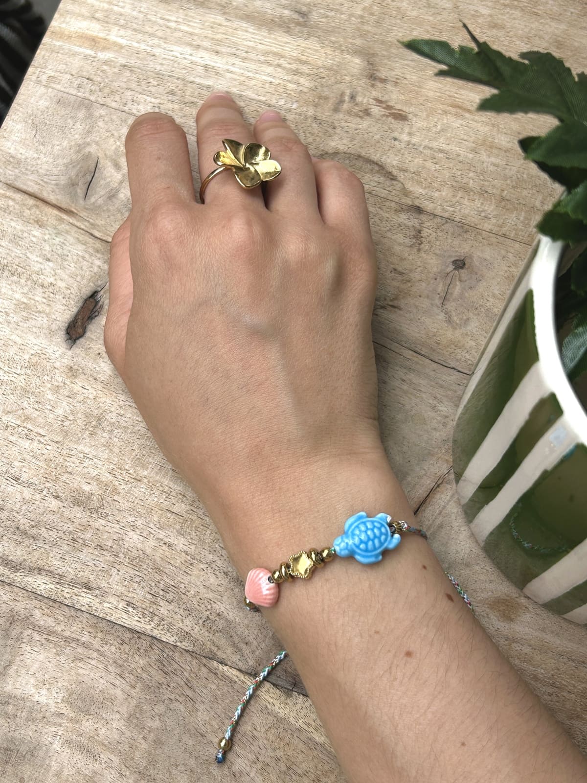 Bracelet cordon tortue bleu porté au poignet d’une femme