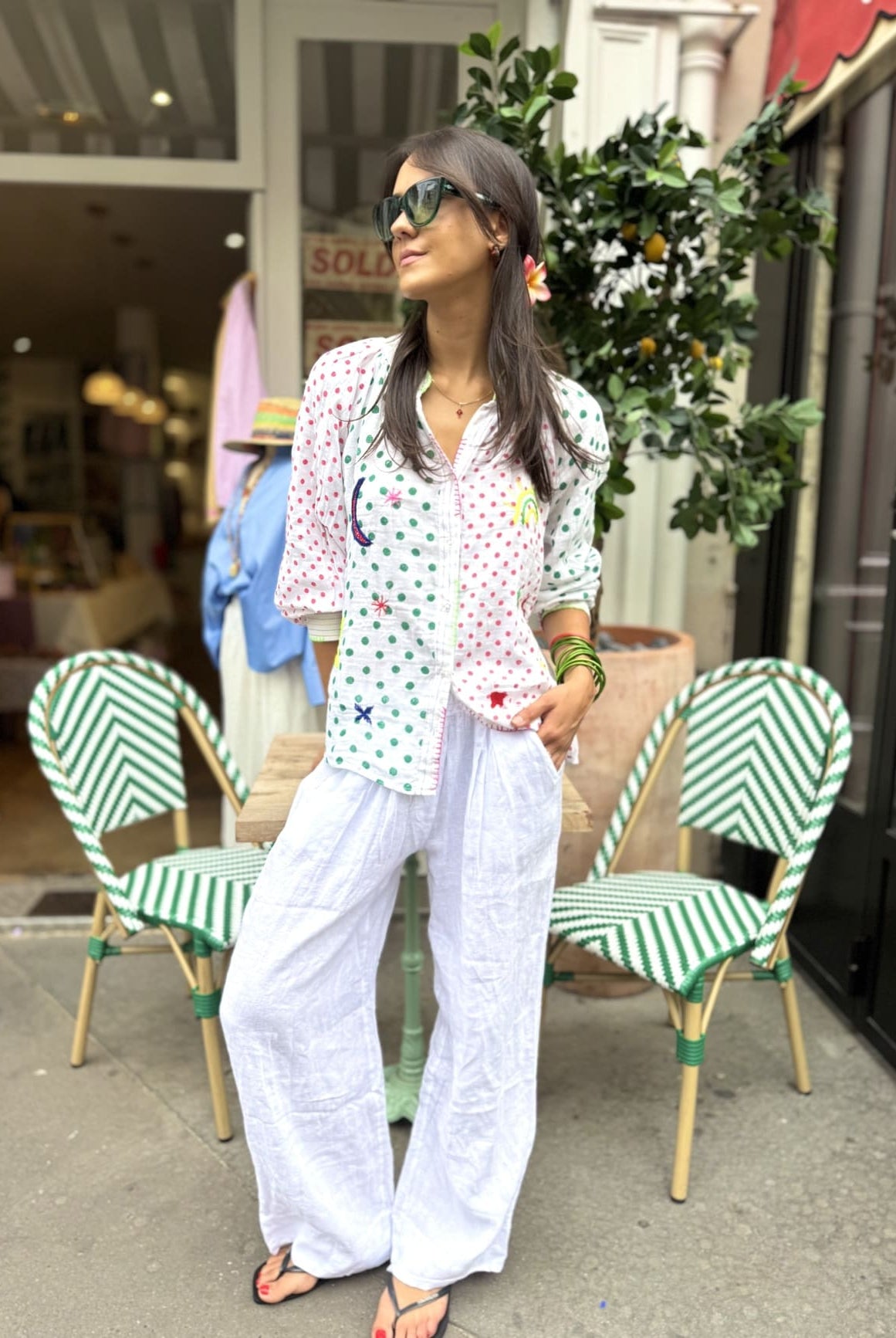 Chemise femme en coton avec des pois rouges et verts sur un pantalon blanc