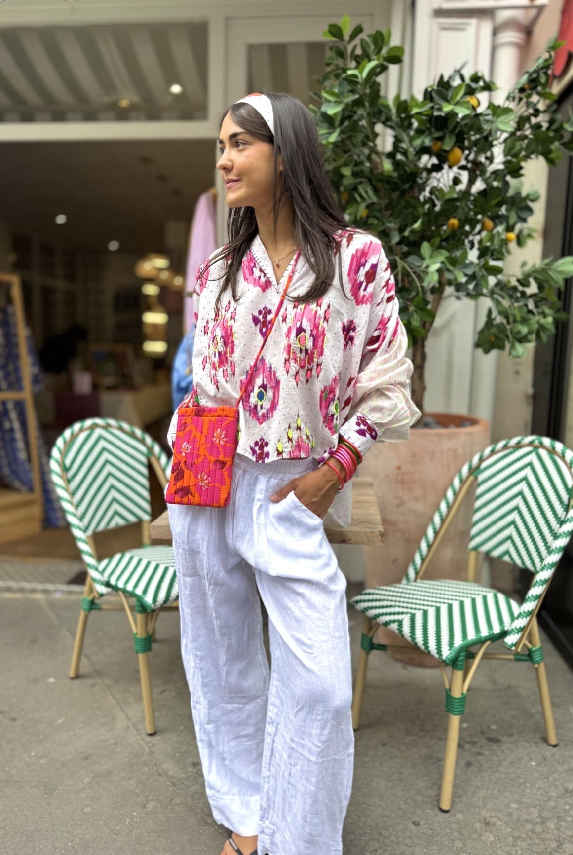 Chemise blanche aux motifs roses portée sur un pantalon blanc