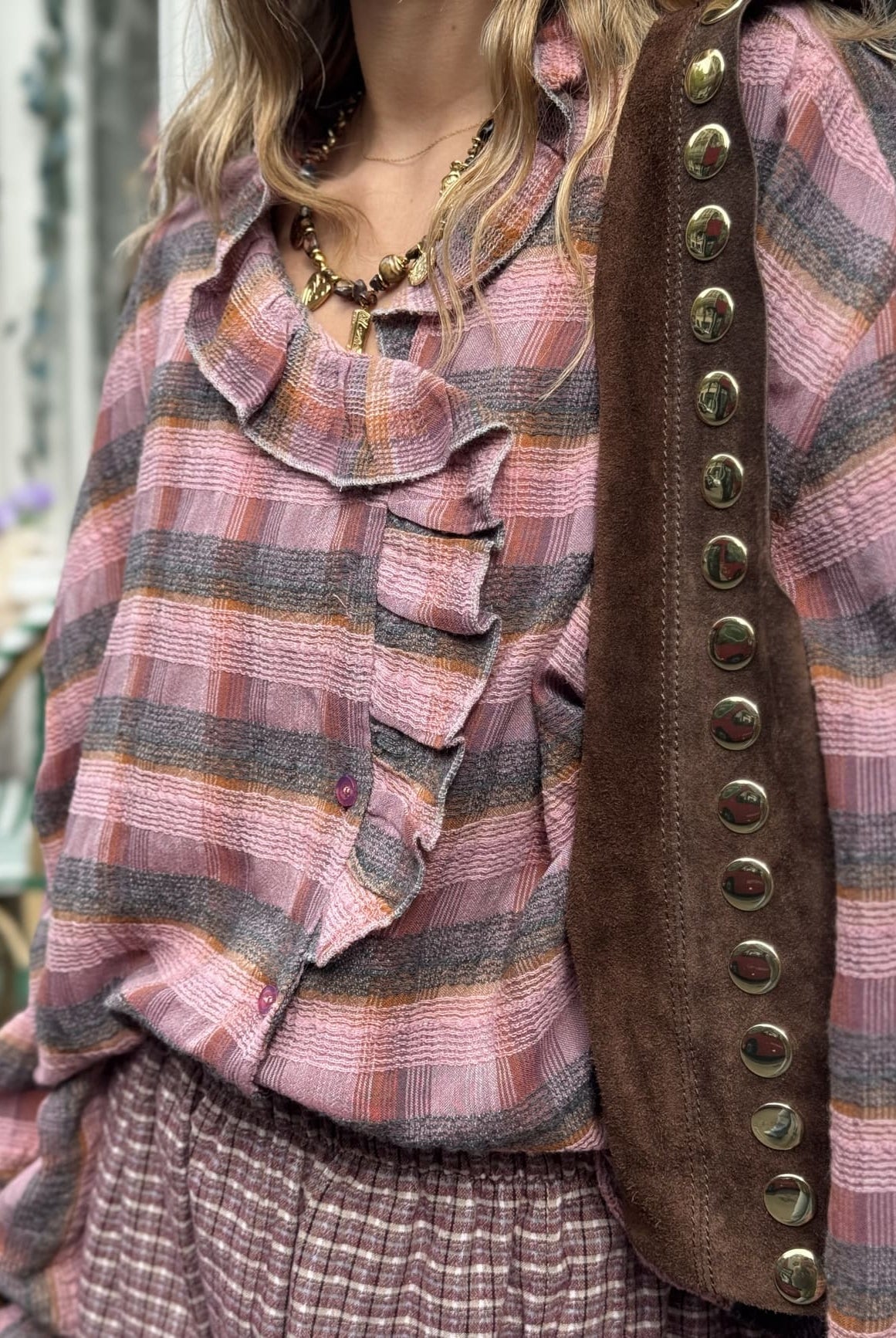 Femme portant la chemise rose et chocolat à volant.