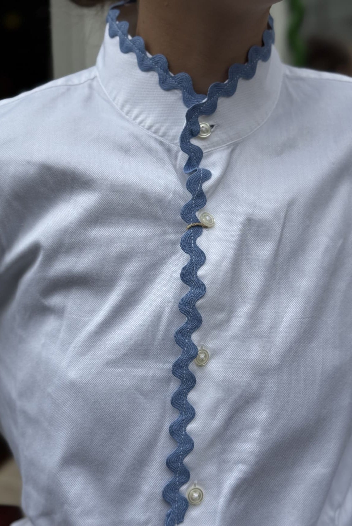 Détail du croquet bleu sur le col de la chemise blanche upcyclée Ensemble Création