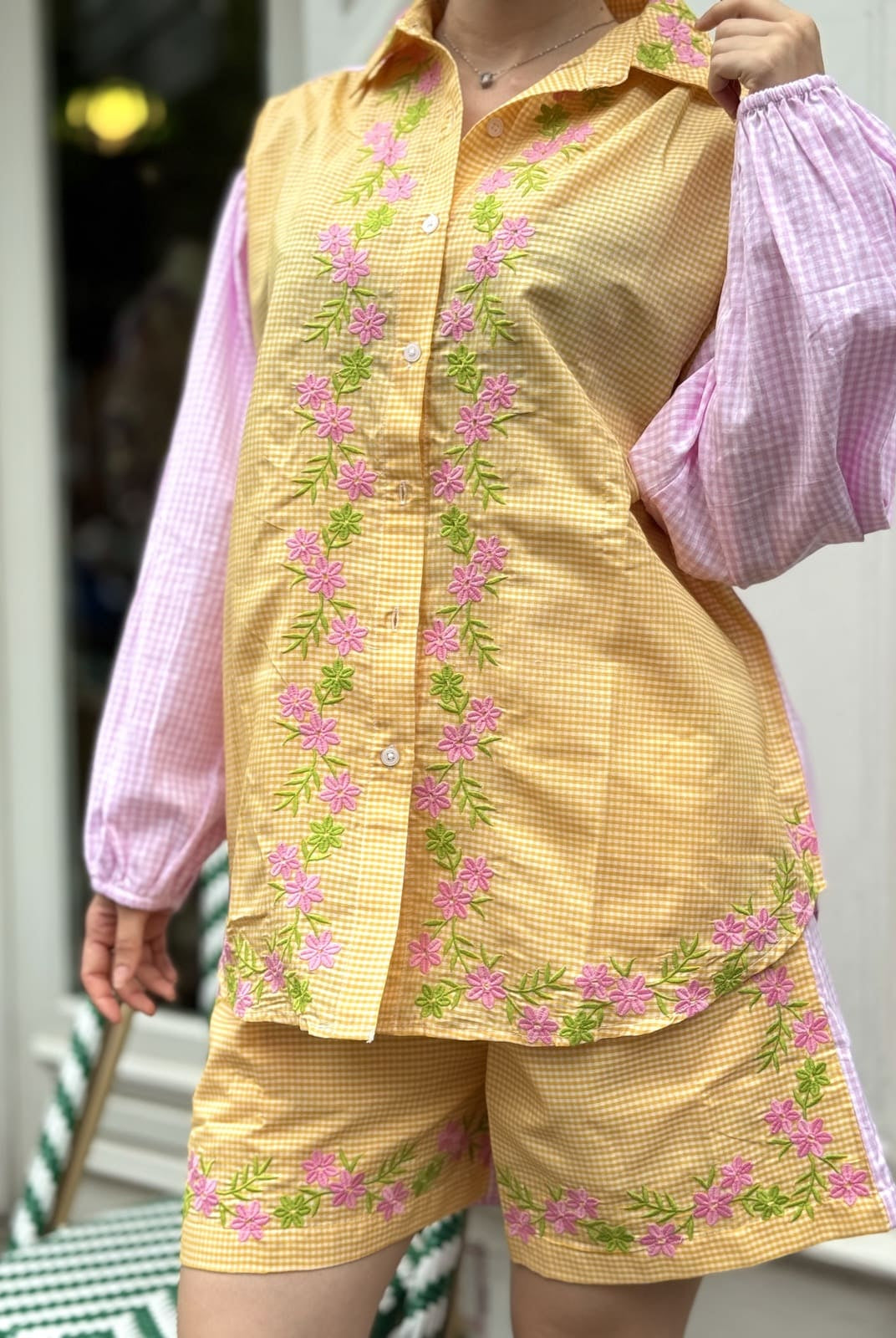 Gros plan sur les broderies de la blouse vichy jaune