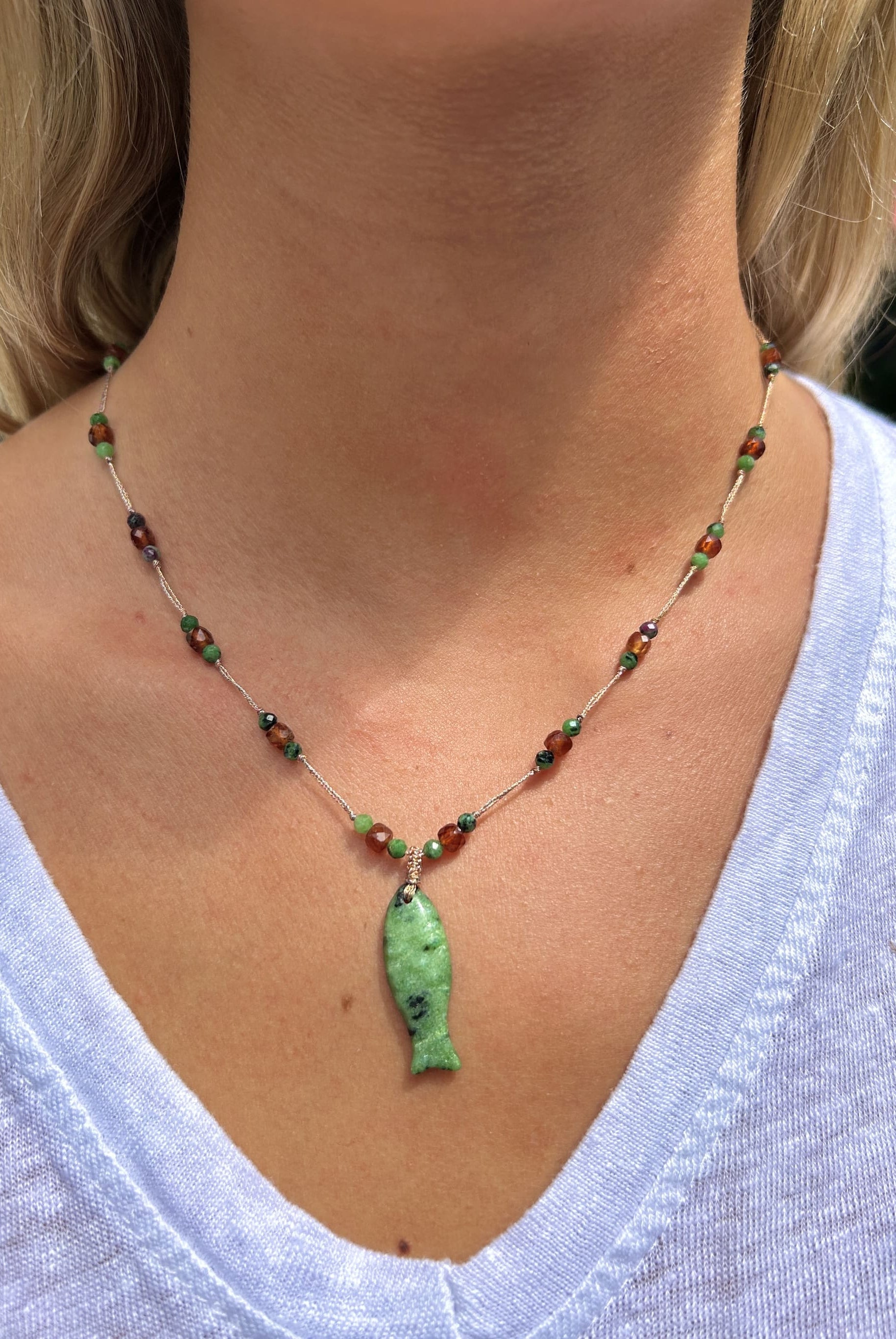 Collier en agate verte avec pampille poisson porté autour du cou, style élégant et naturel
