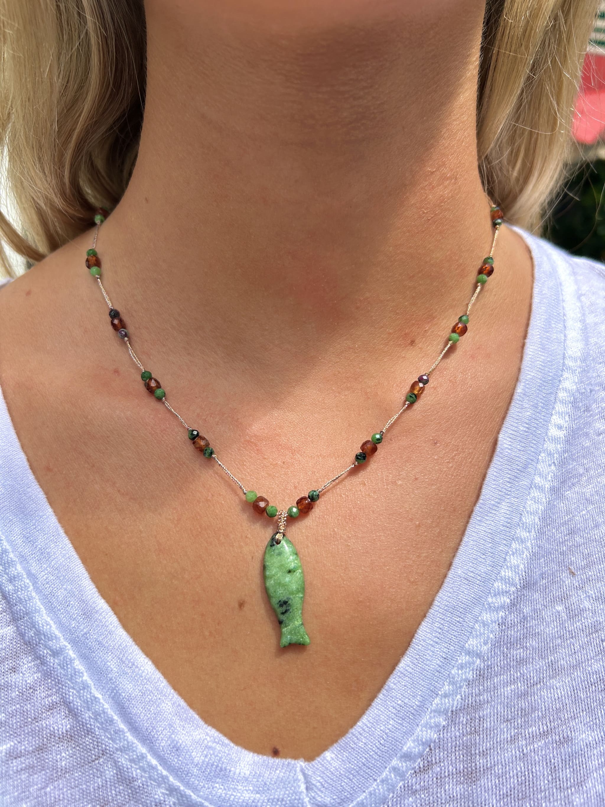 Collier en agate verte avec pampille poisson porté autour du cou, style élégant et naturel