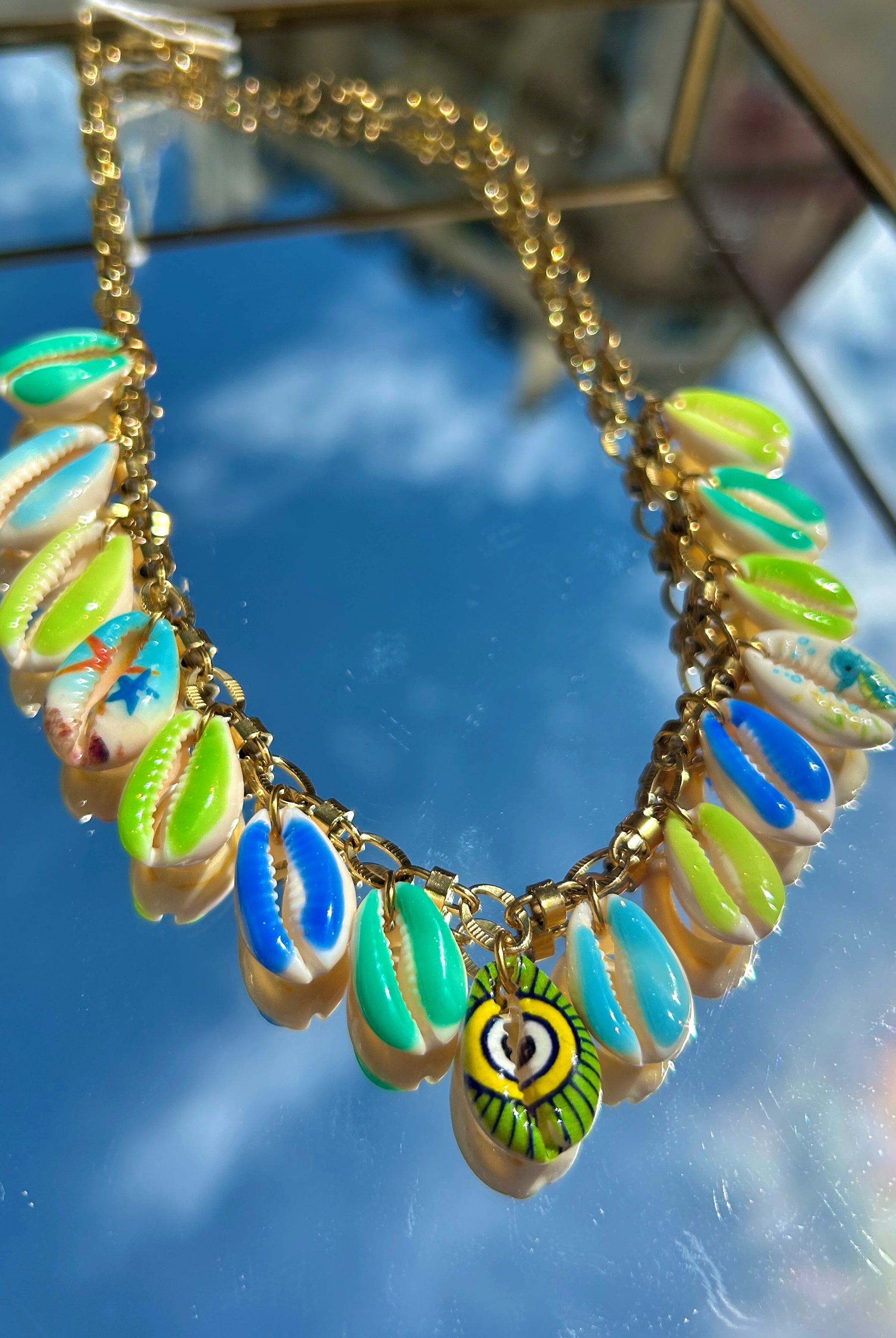 Gros plan des breloques coquillage vert et bleu