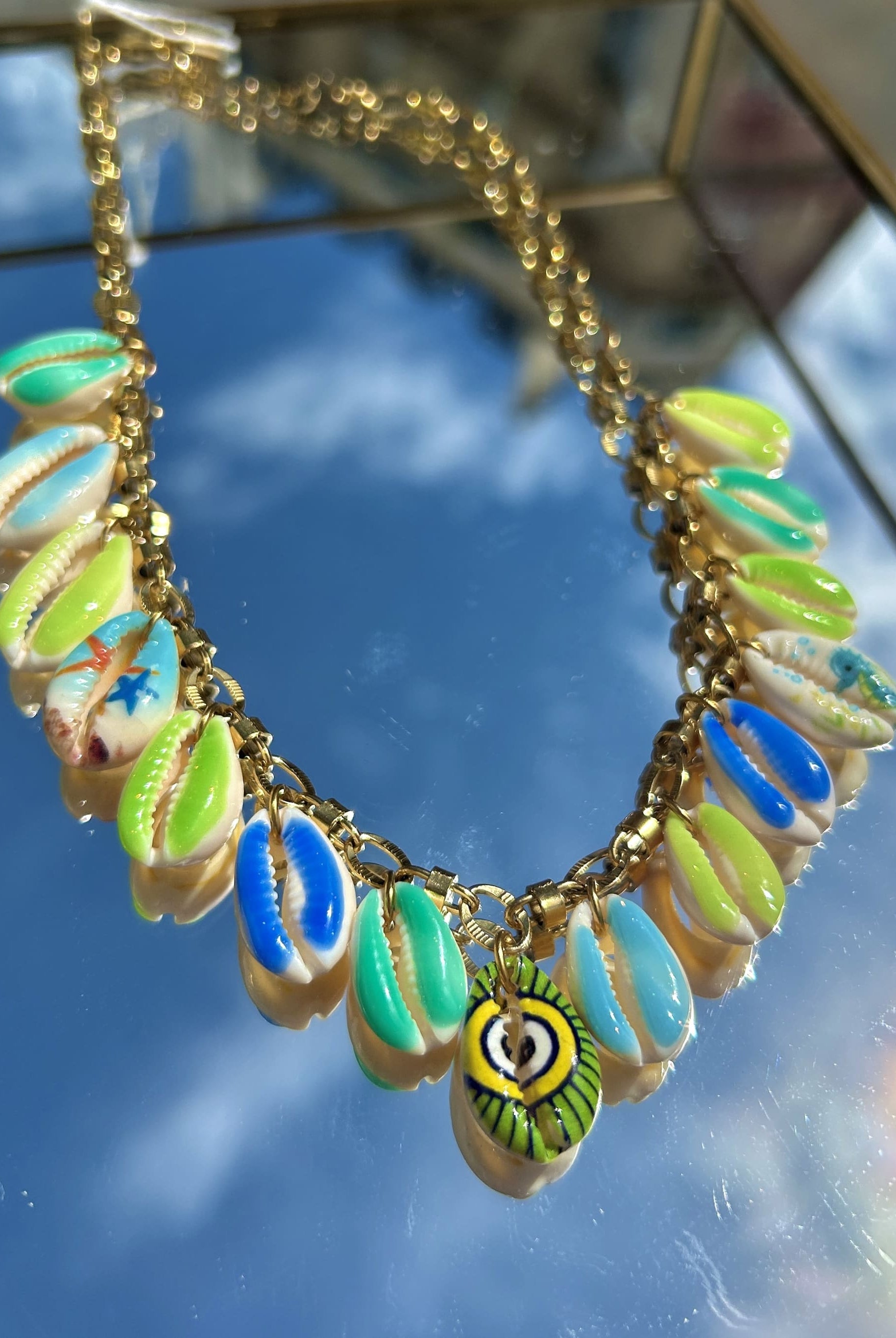 Gros plan des breloques coquillage vert et bleu