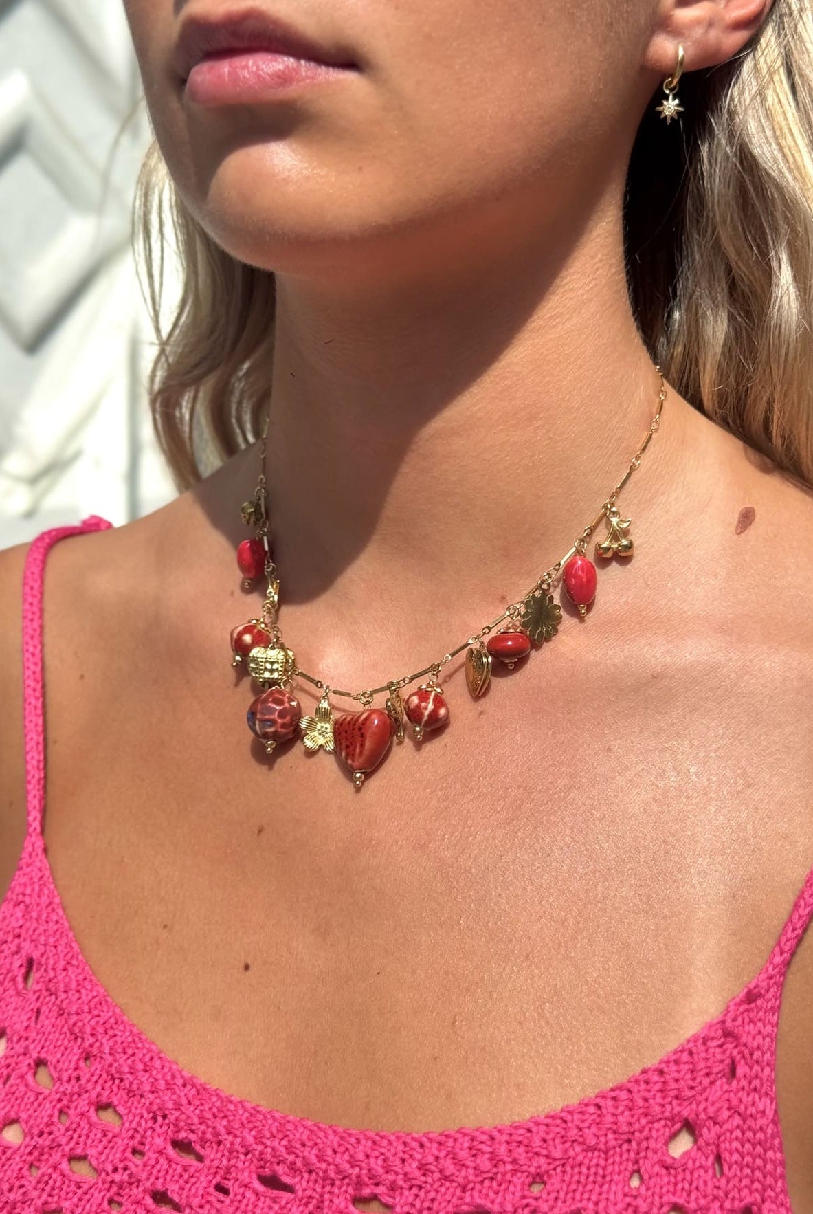 Collier breloque rouge porté – chaîne dorée élégante femme