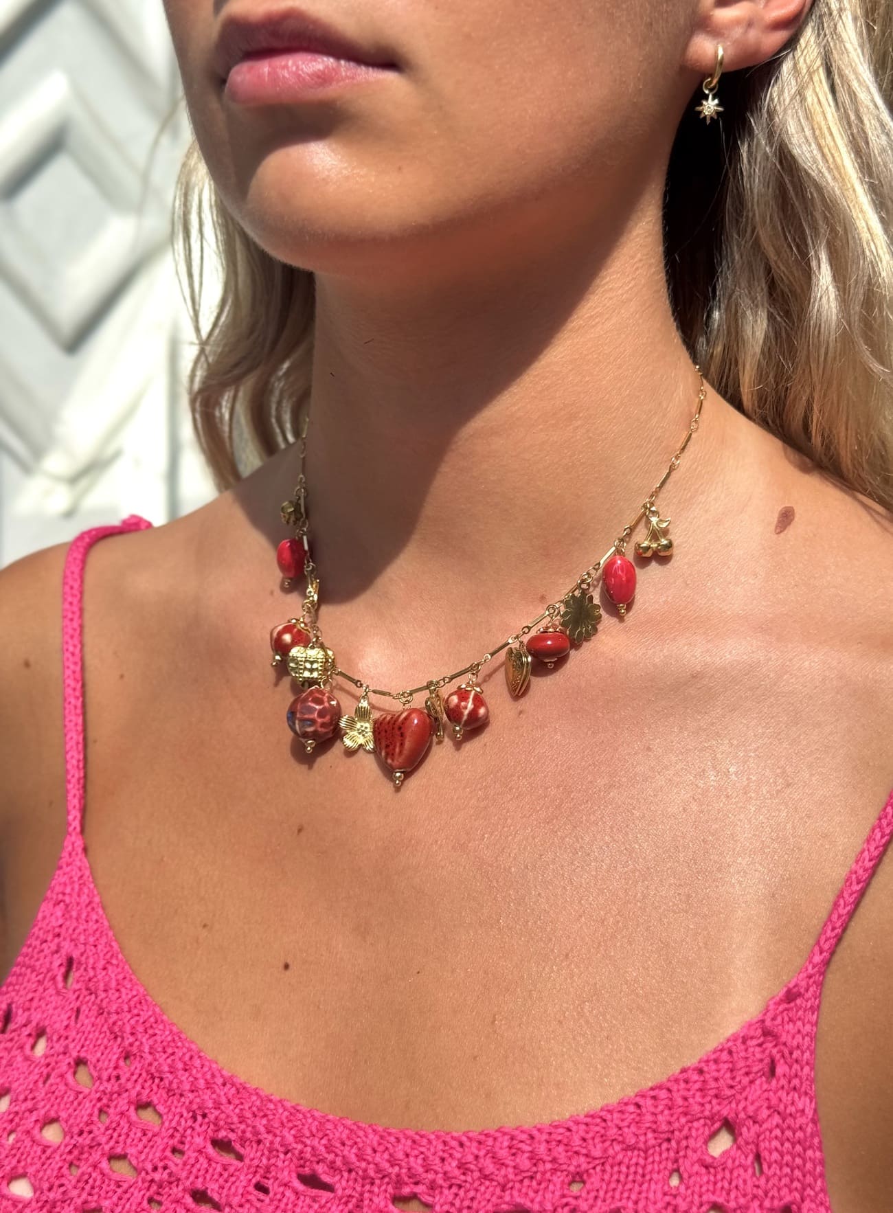 Collier breloque rouge porté – chaîne dorée élégante femme