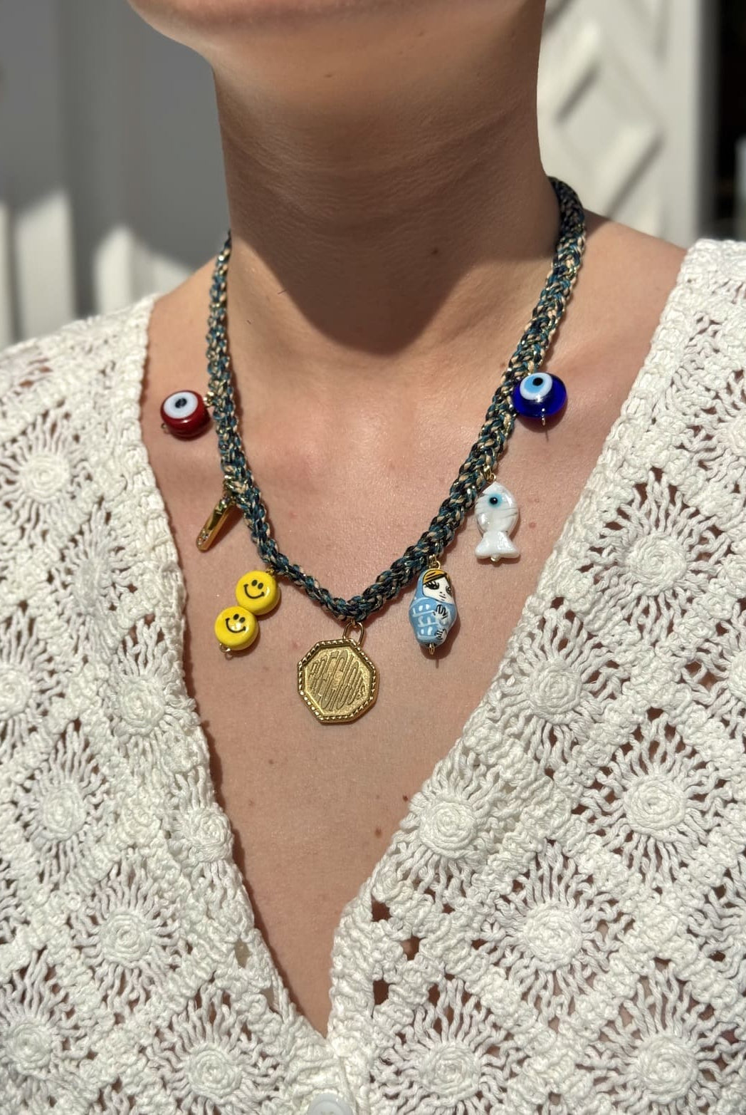 Collier Kchoush tressé bleu porté avec 7 charms symbolisant la guérison et l’énergie precious
