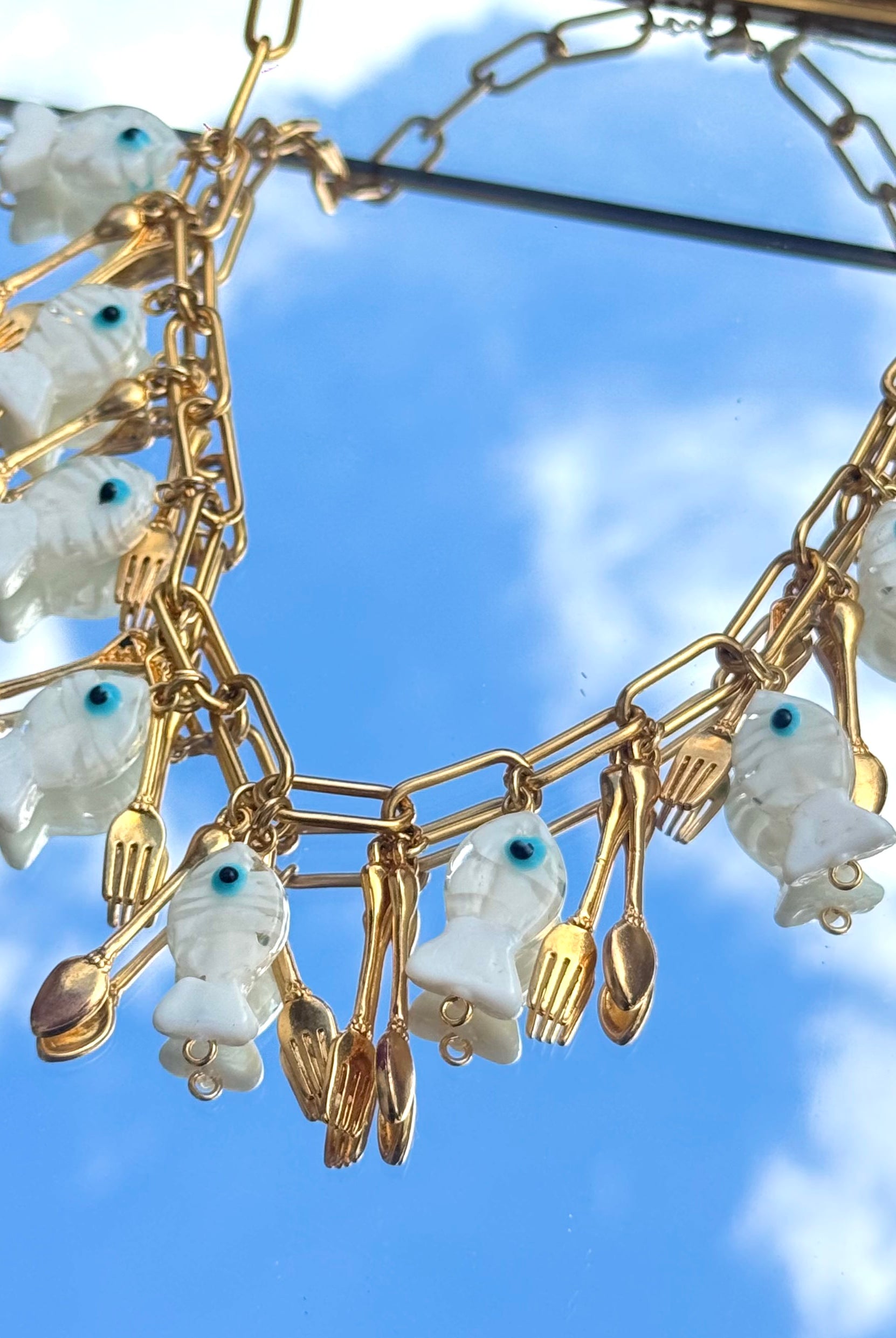 Gros plan du collier Kchoush avec breloque poisson et couvert
