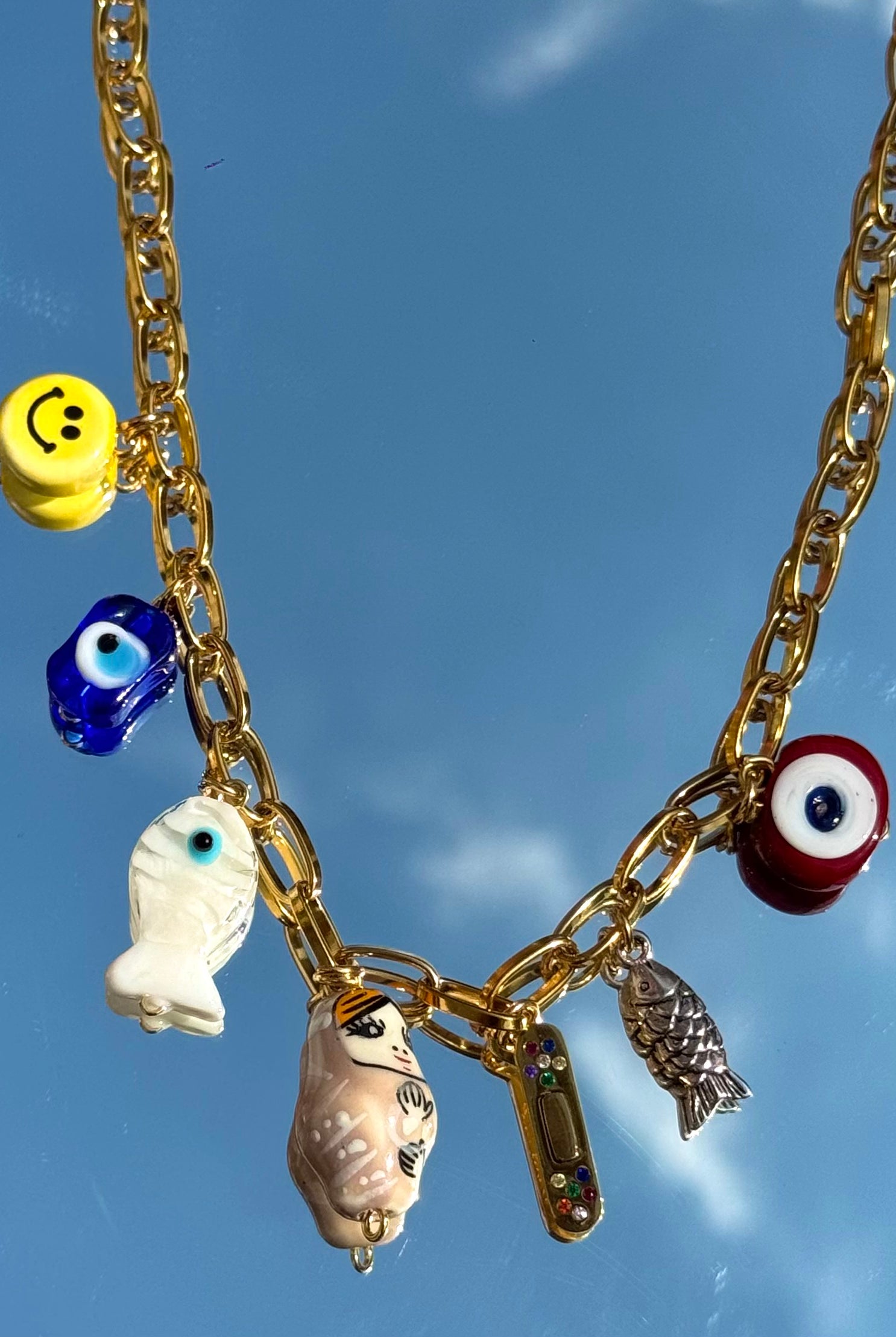 Détail du collier Mamie Colette – charms symbolisant la guérison, l'abondance et la protection