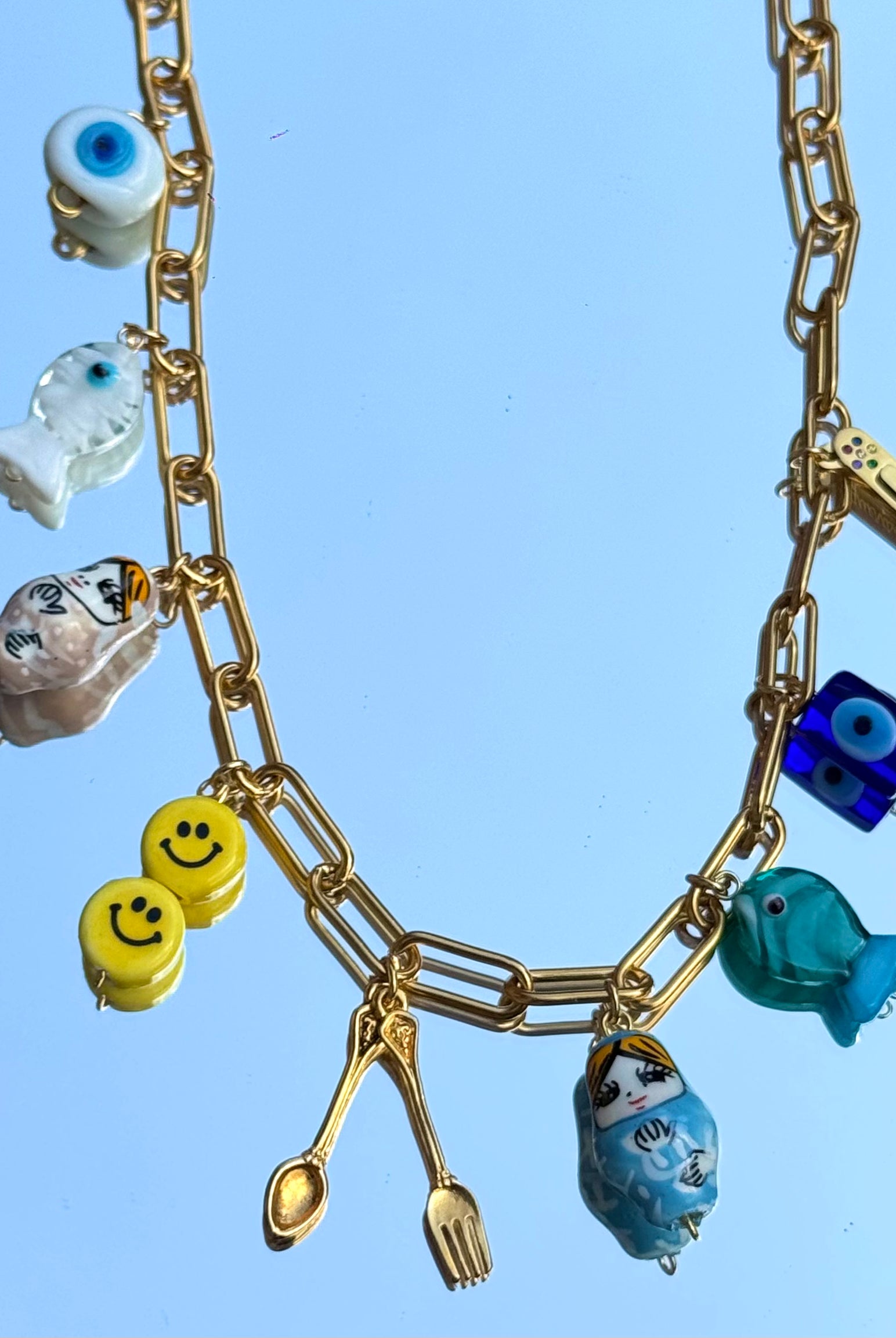 Gros plan sur les 9 charms du collier Mamie Esther – symboles de protection, chance et santé