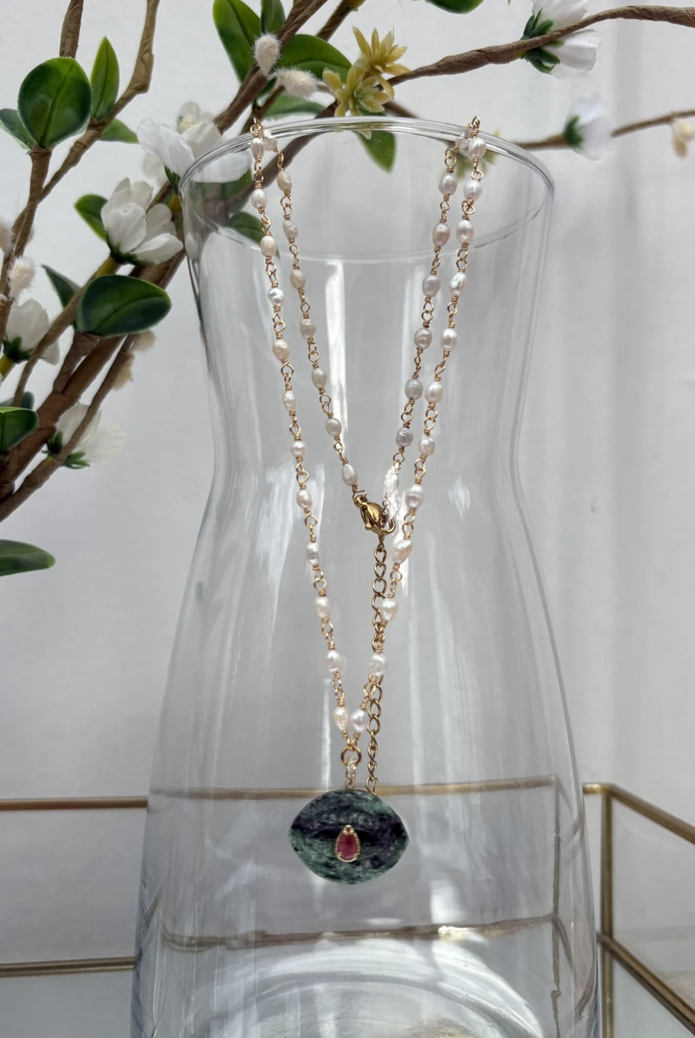 Collier en nacre et pierre d'agate verte suspendu à une carafe