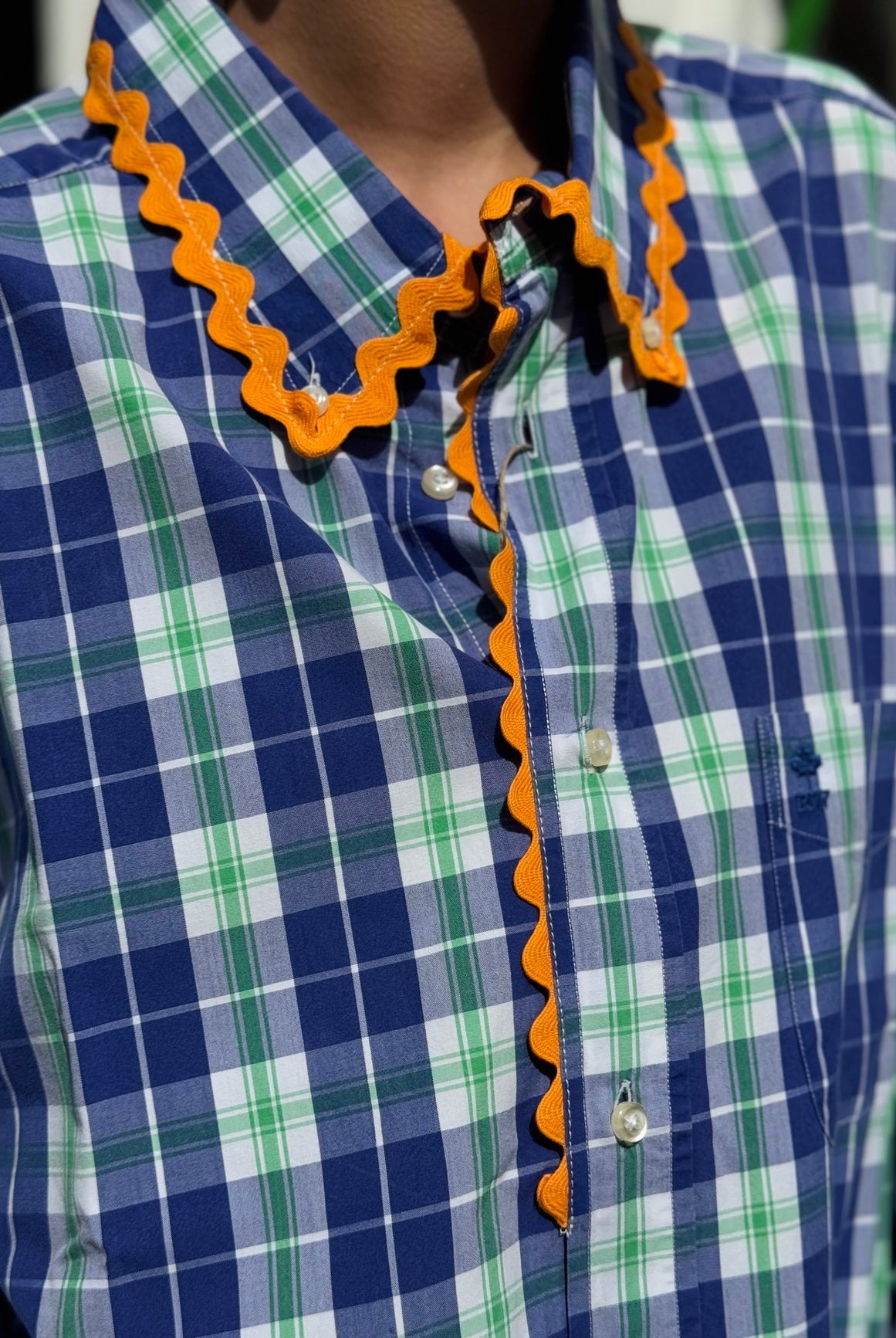 Détail du galon orange de la chemise upcyclée bleu et verte