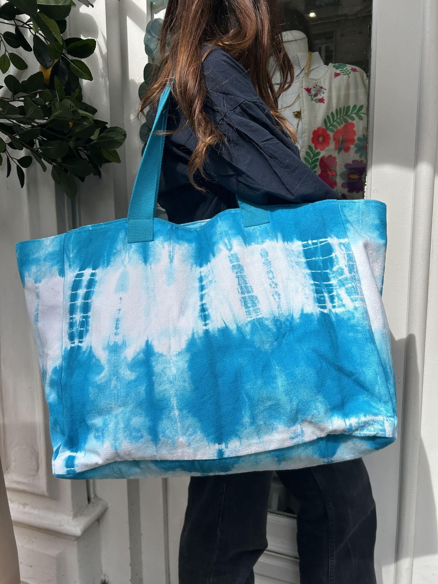 Femme portant le cabas tie & dye bleu turquoise à l’épaule