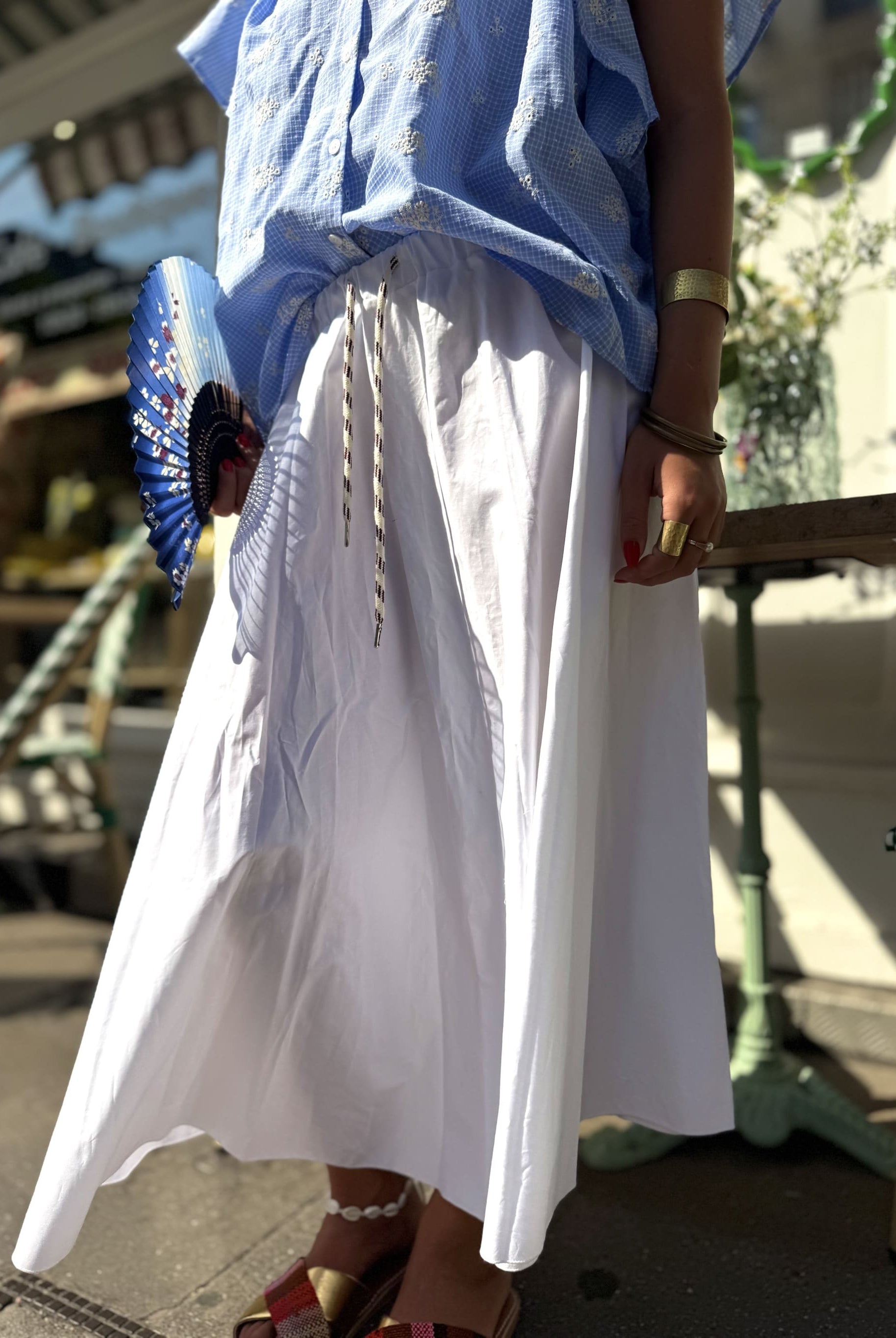 Détail gros plan de la forme corolle de la jupe blanche, tombé fluide et évasé