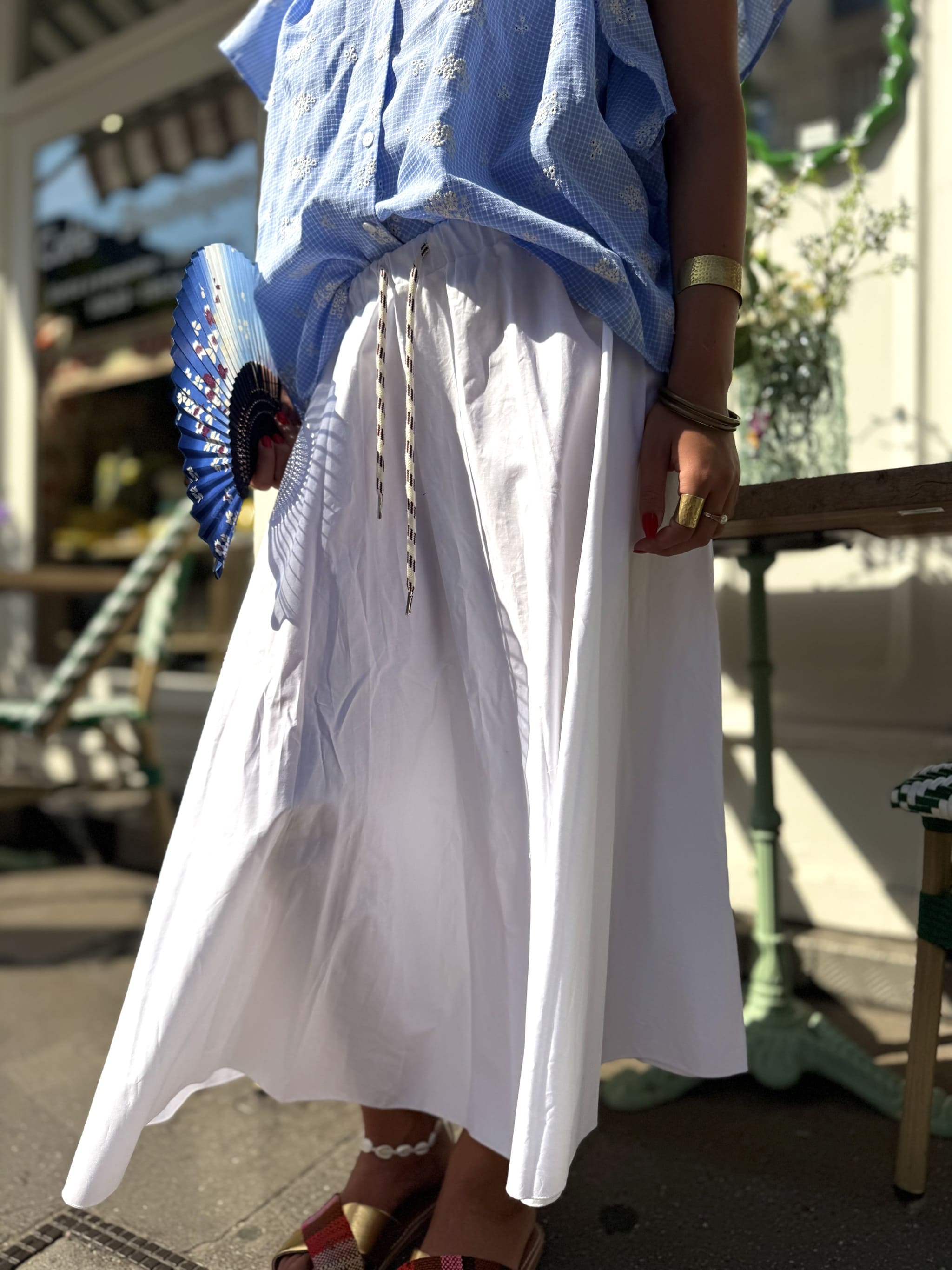 Détail gros plan de la forme corolle de la jupe blanche, tombé fluide et évasé