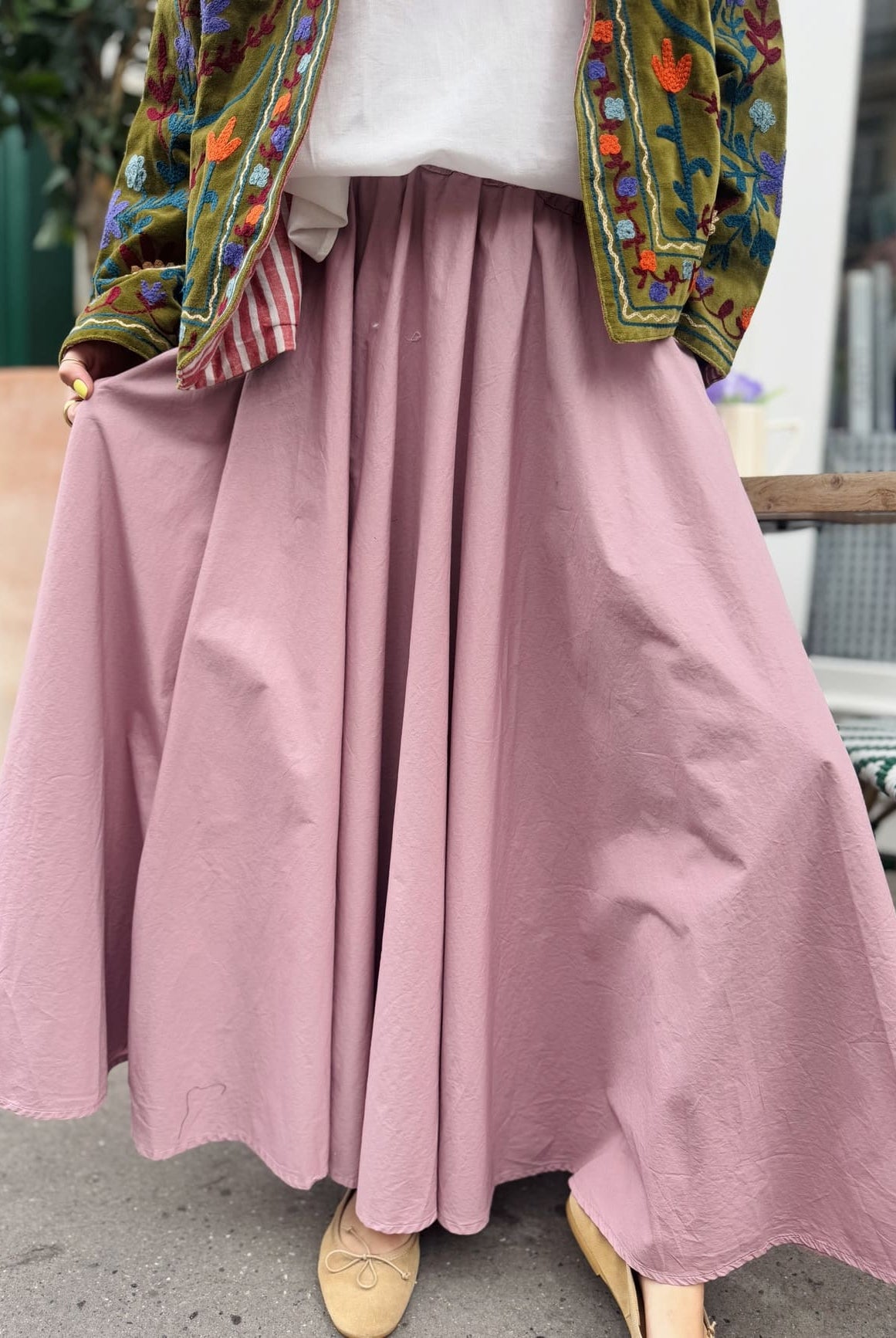 Gros plan sur la jupe longue forme corolle en coton rose poudré