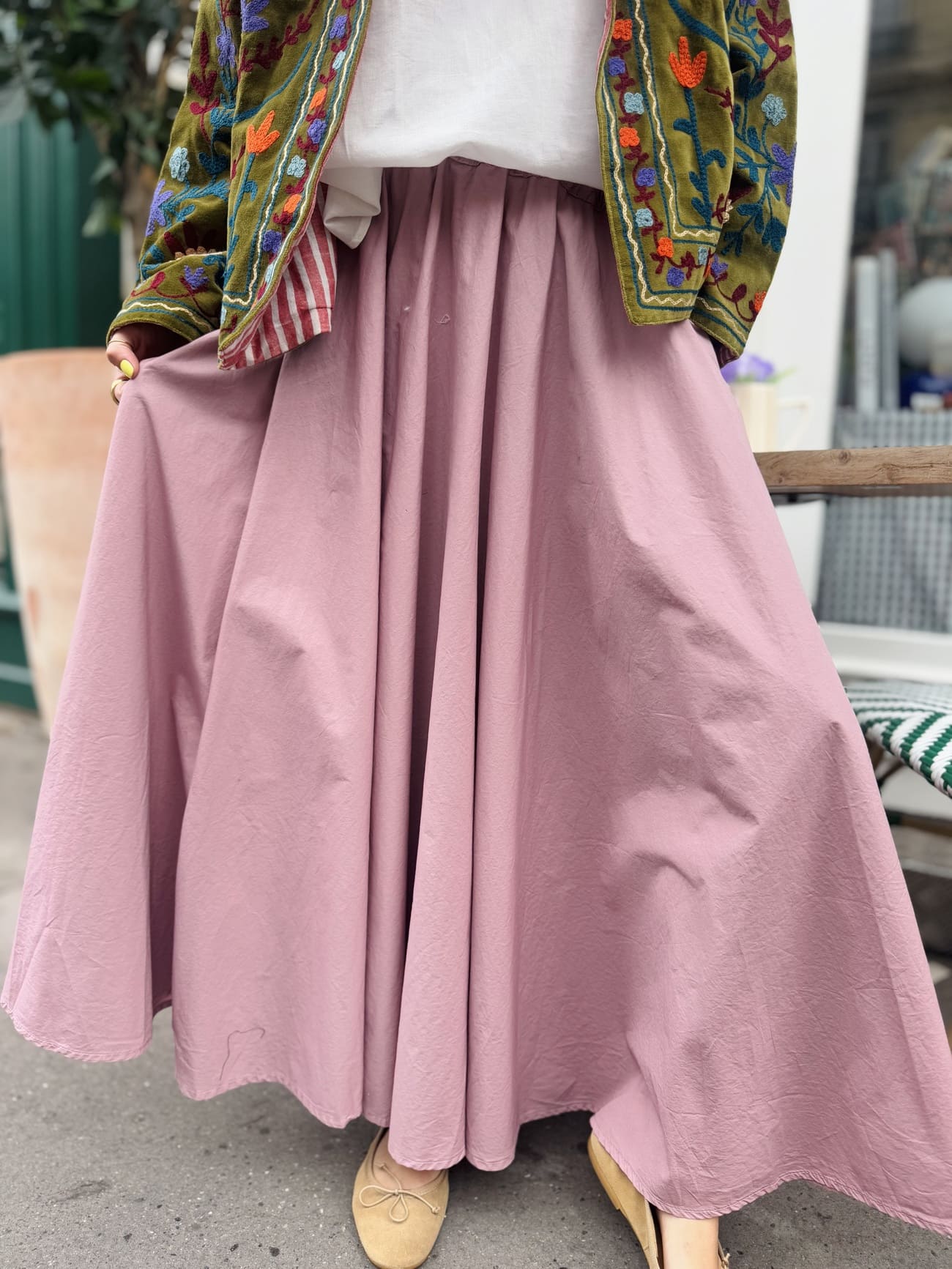 Gros plan sur la jupe longue forme corolle en coton rose poudré