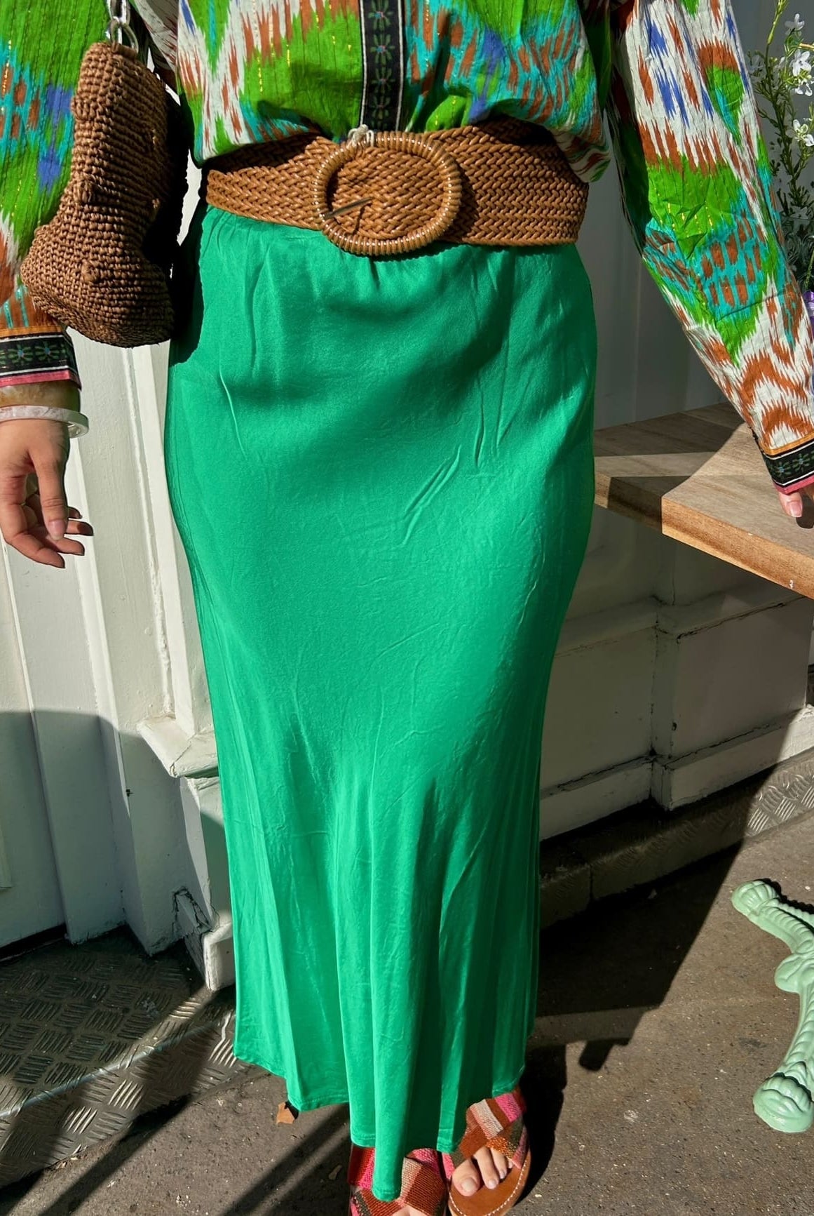 Détail du tissu satin vert émeraude de la jupe fluide