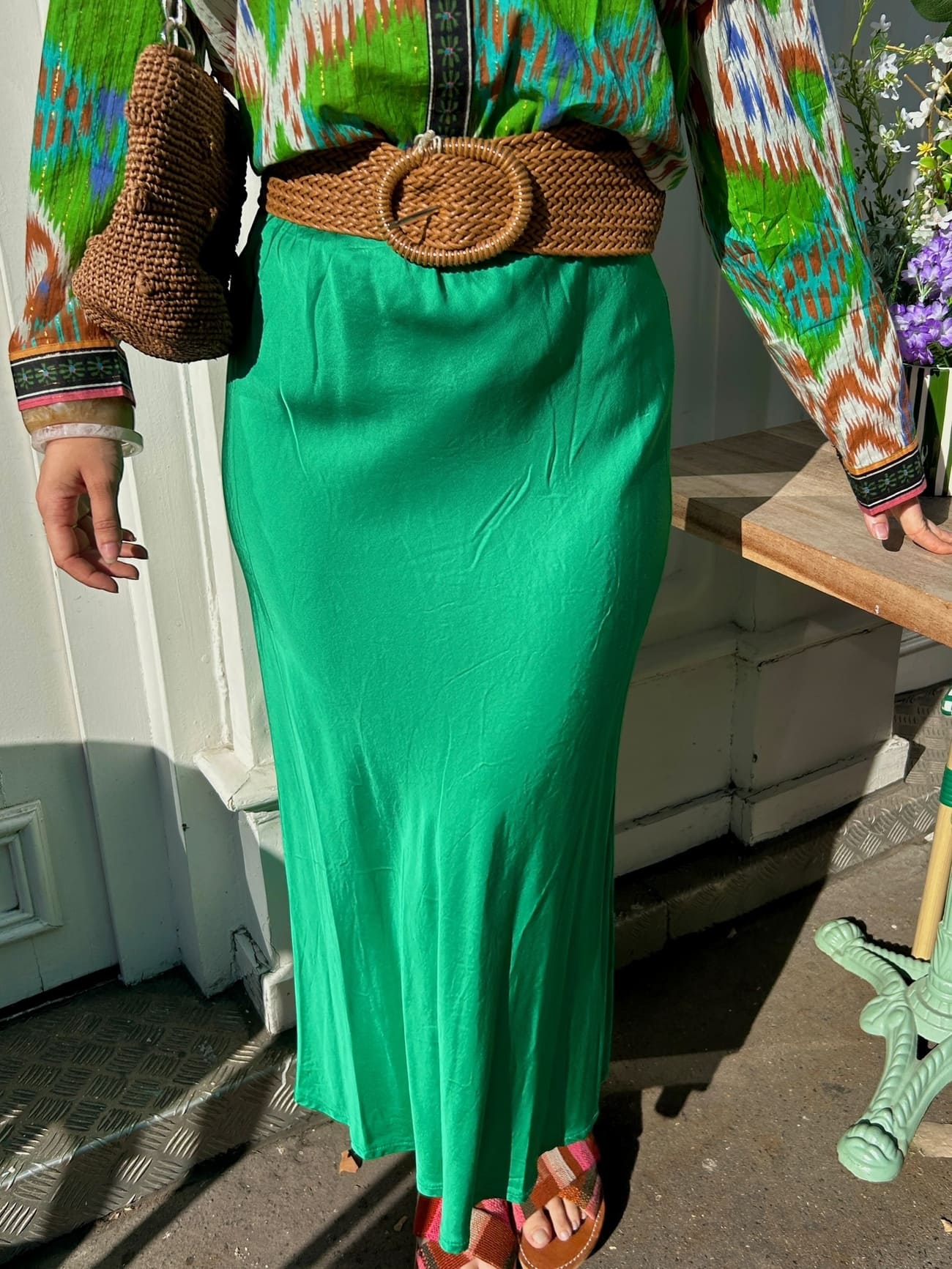 Détail du tissu satin vert émeraude de la jupe fluide