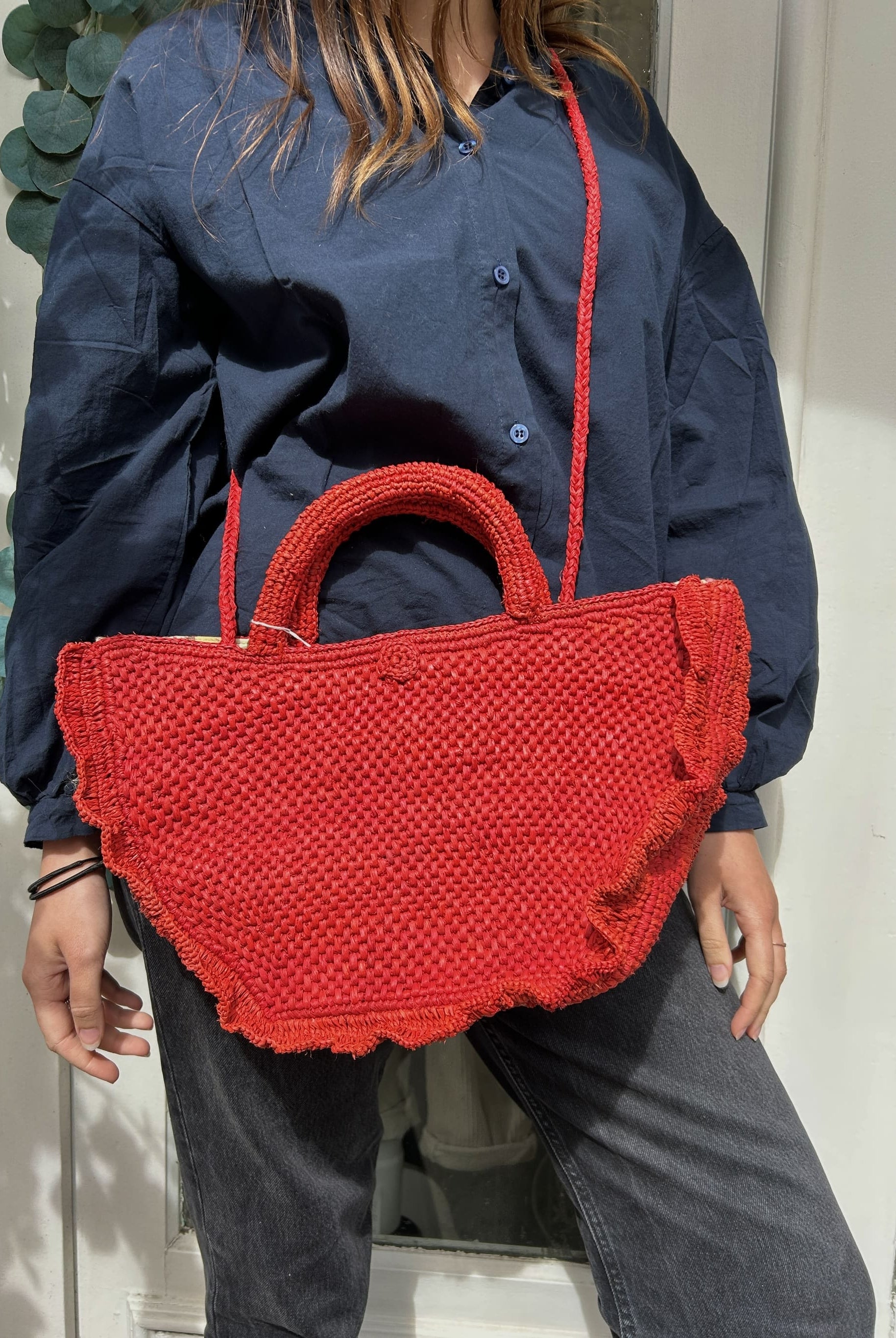 Panier rouge porté en bandoulière, tressage artisanal