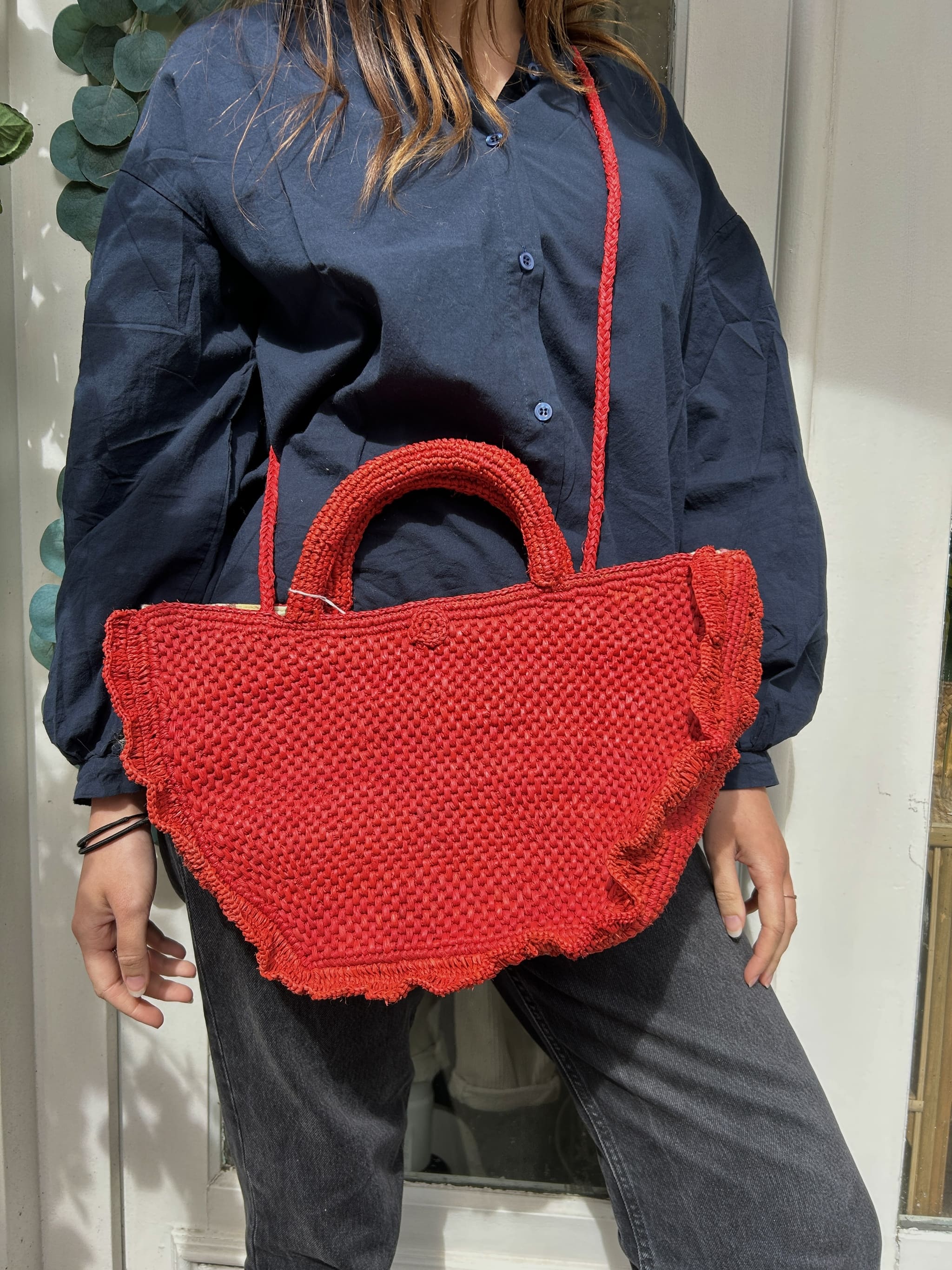 Panier rouge porté en bandoulière, tressage artisanal