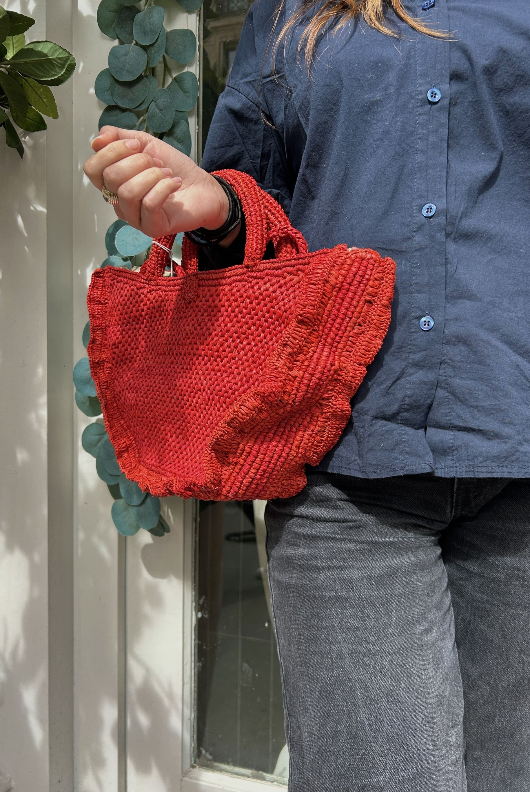 Panier rouge porté à la main, tressage artisanal