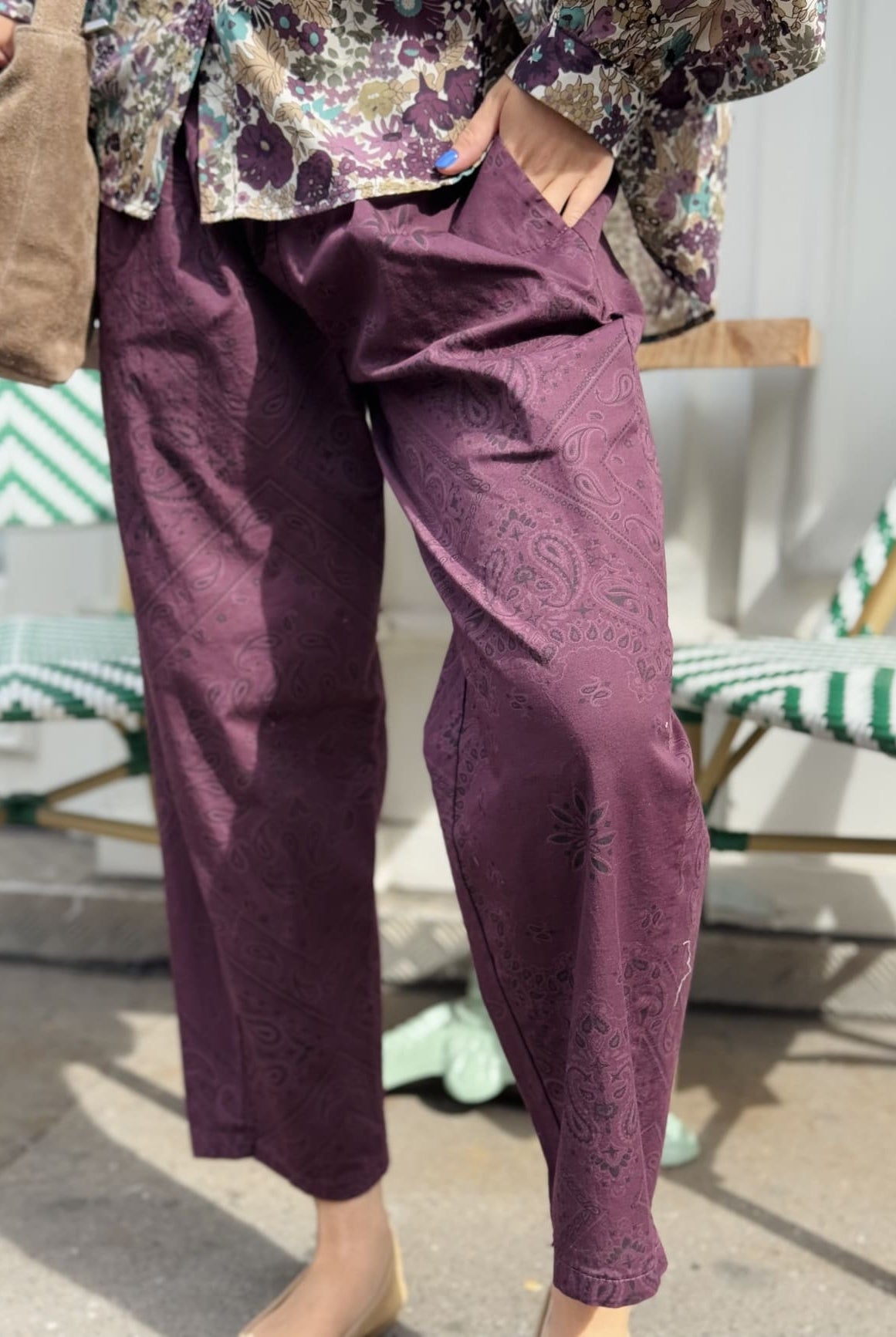 Gros plan sur le pantalon bordeaux au motif paisley