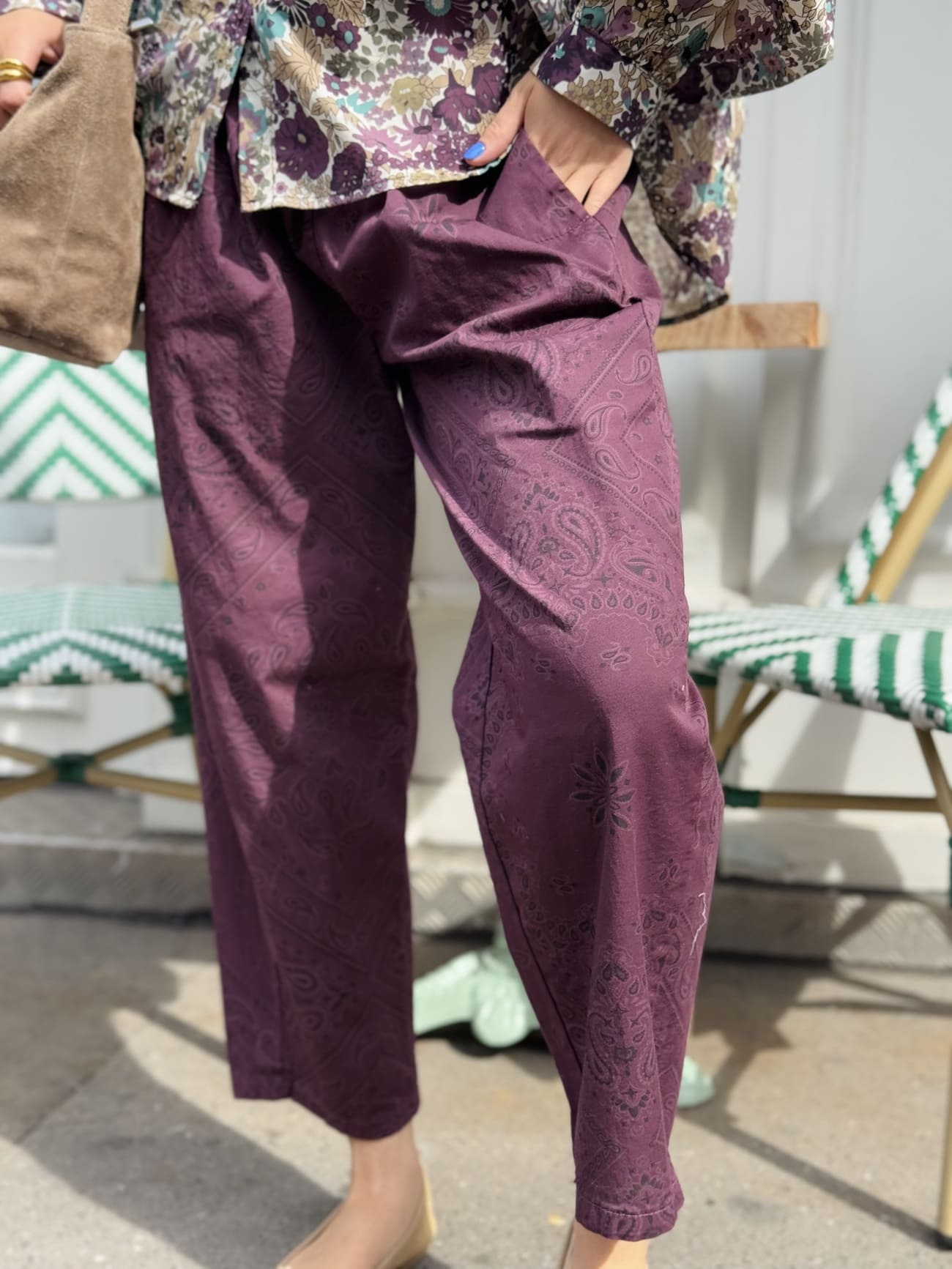 Gros plan sur le pantalon bordeaux au motif paisley