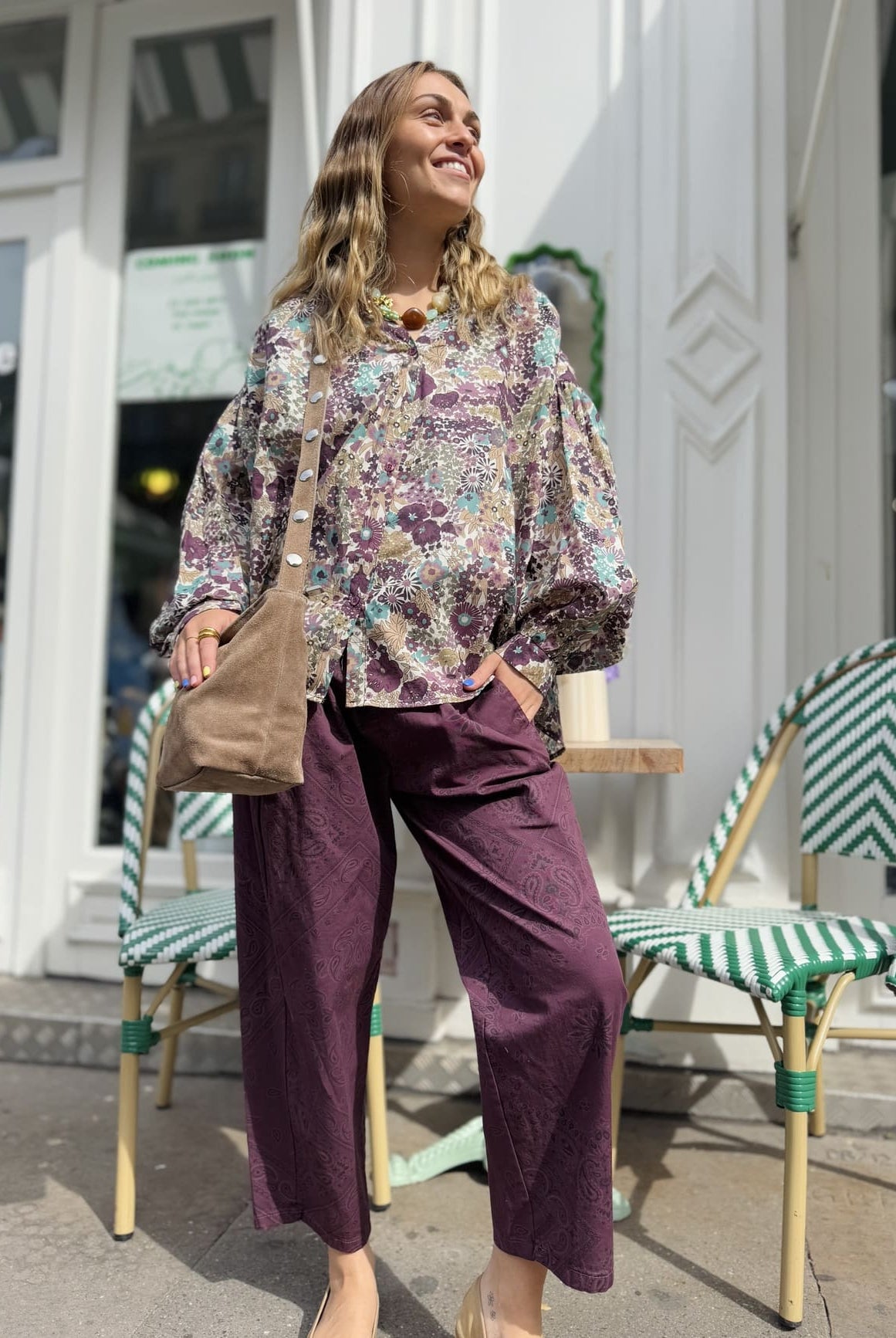 Femme vue de pied portant le pantalon en coton bordeaux au motif paisley