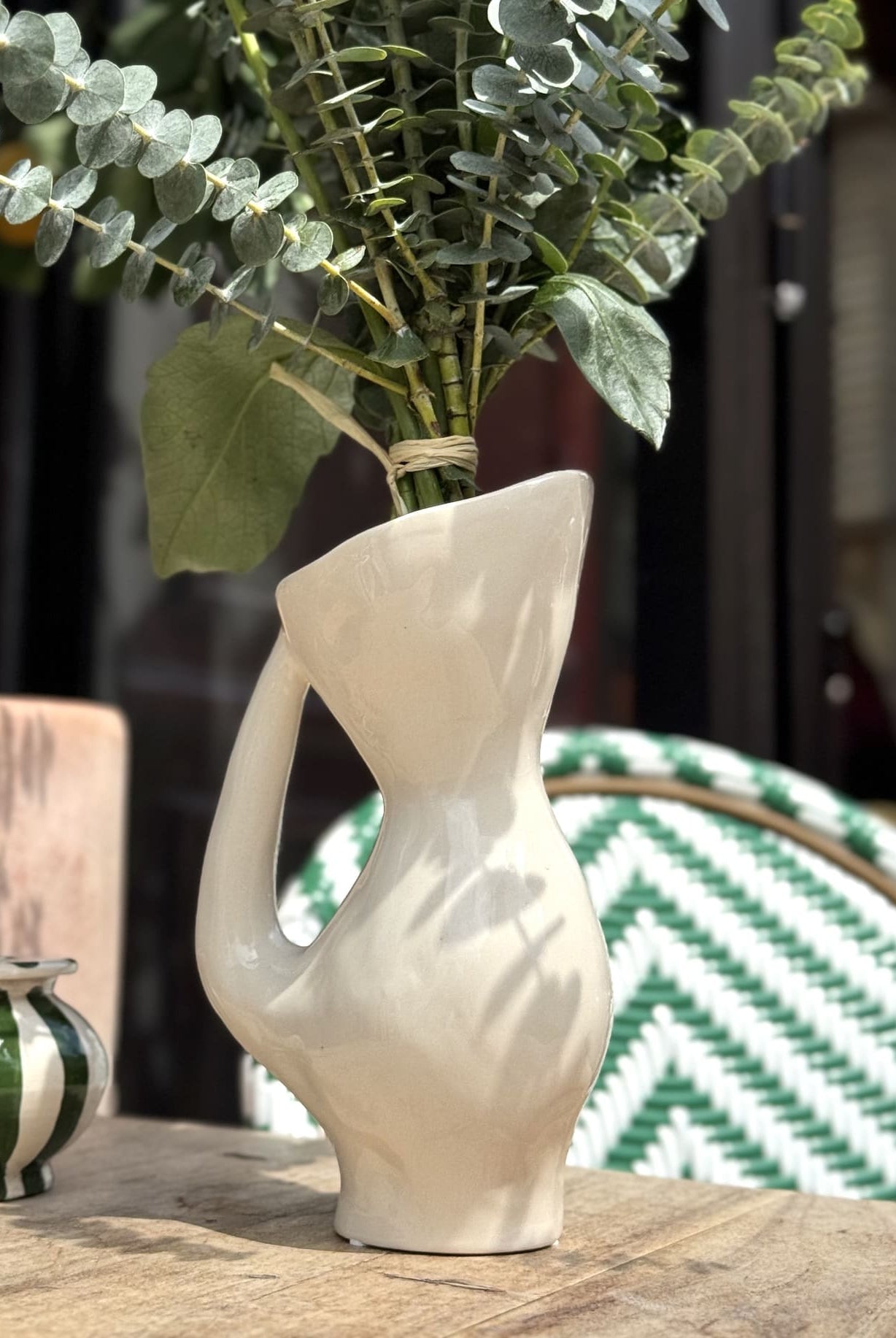 Pichet polyvalent utilisé comme vase décoratif, rempli de fleurs