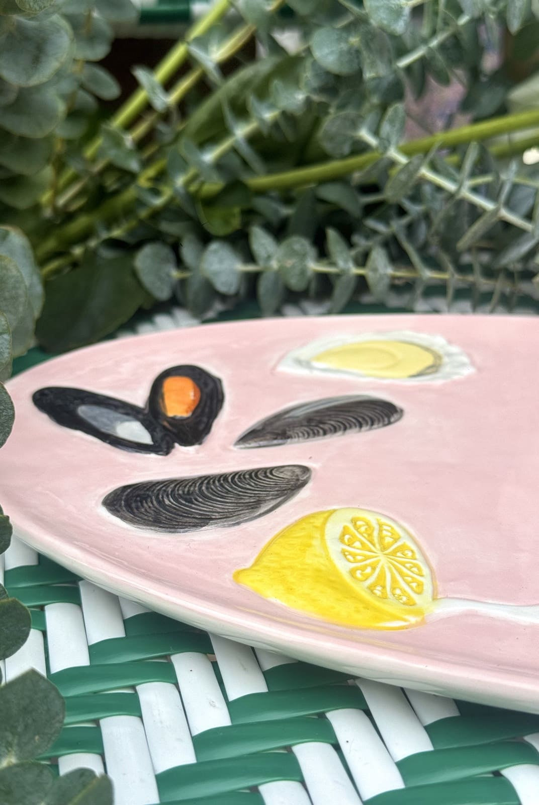 Détail peint à la main : huîtres, moules et tranches de citron sur plat rose