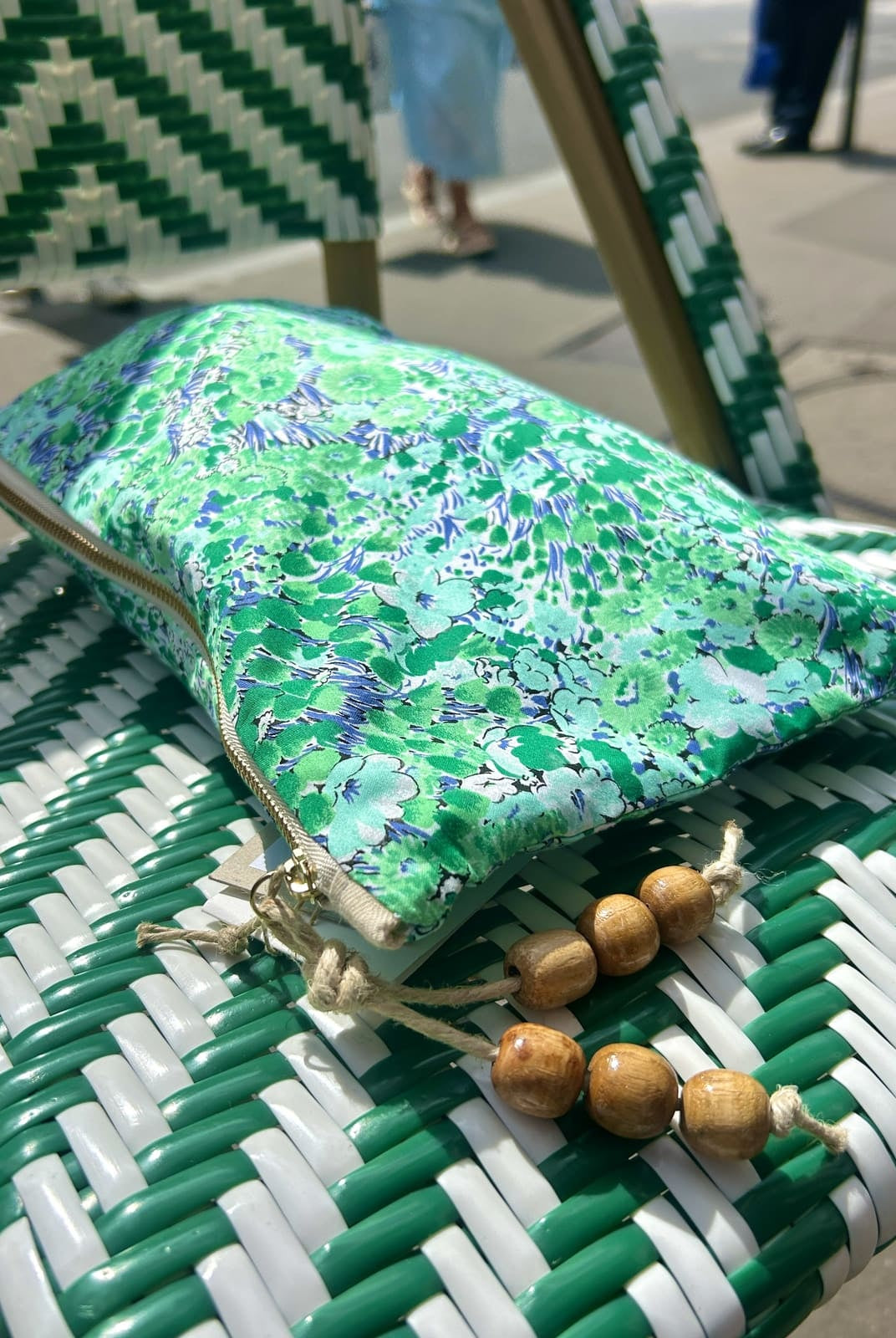 Pochette verte imprimée de petites fleurs, finition pompon en perles de bois