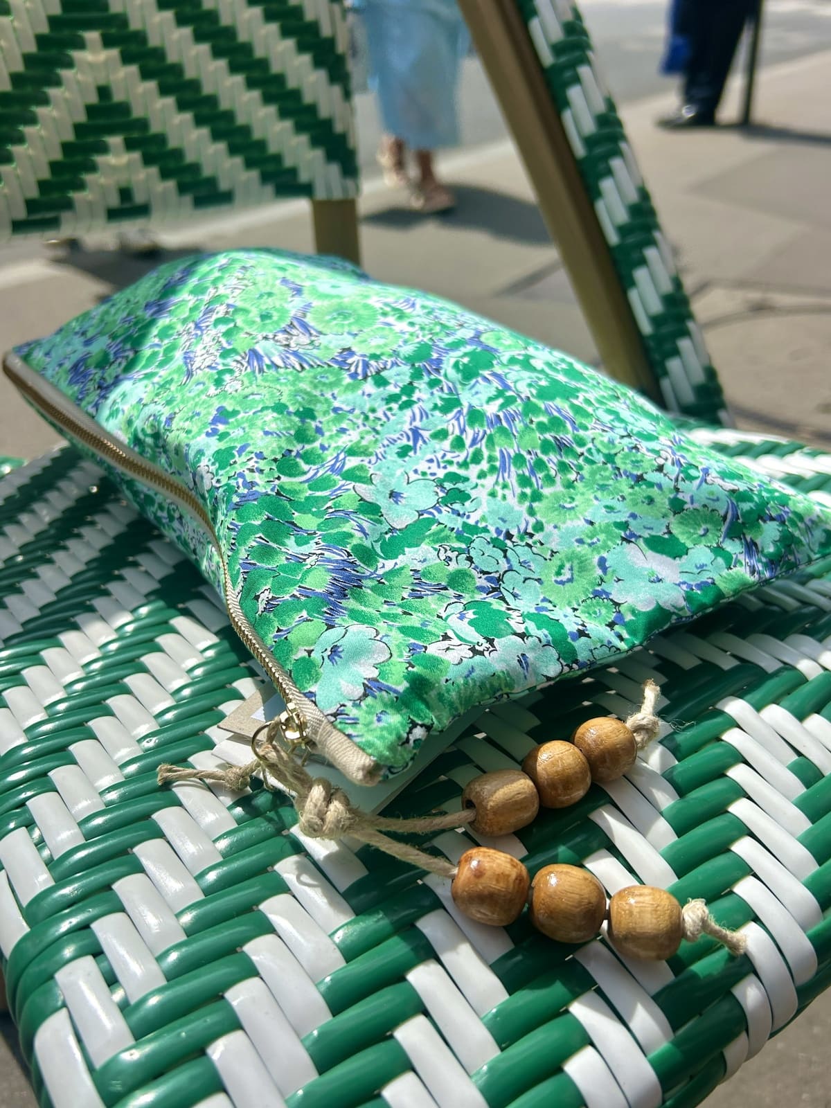 Pochette verte imprimée de petites fleurs, finition pompon en perles de bois