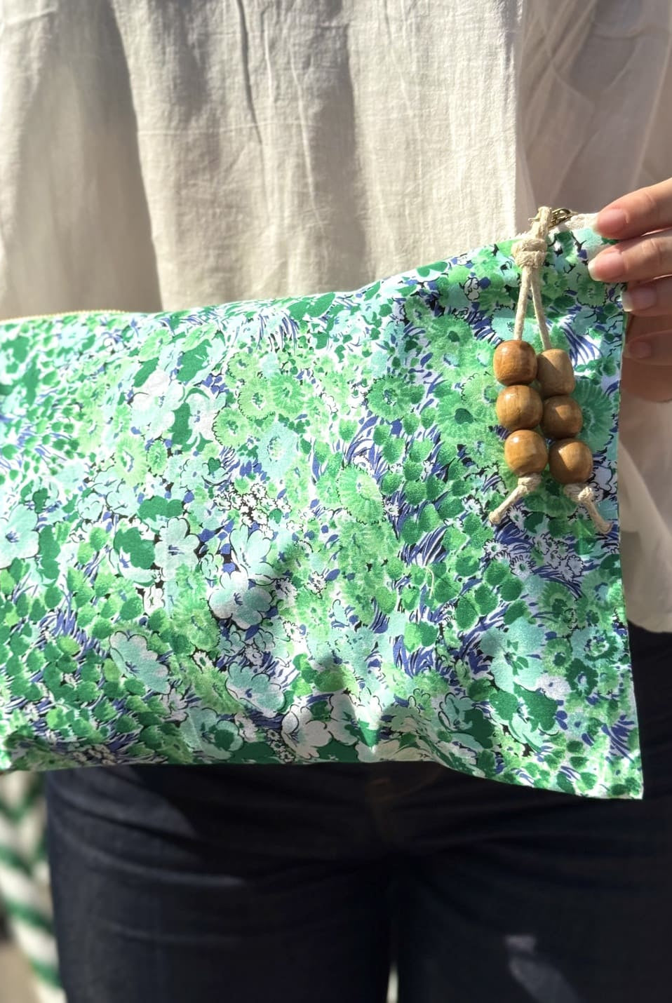 Femme portant une pochette verte imprimée de petites fleurs