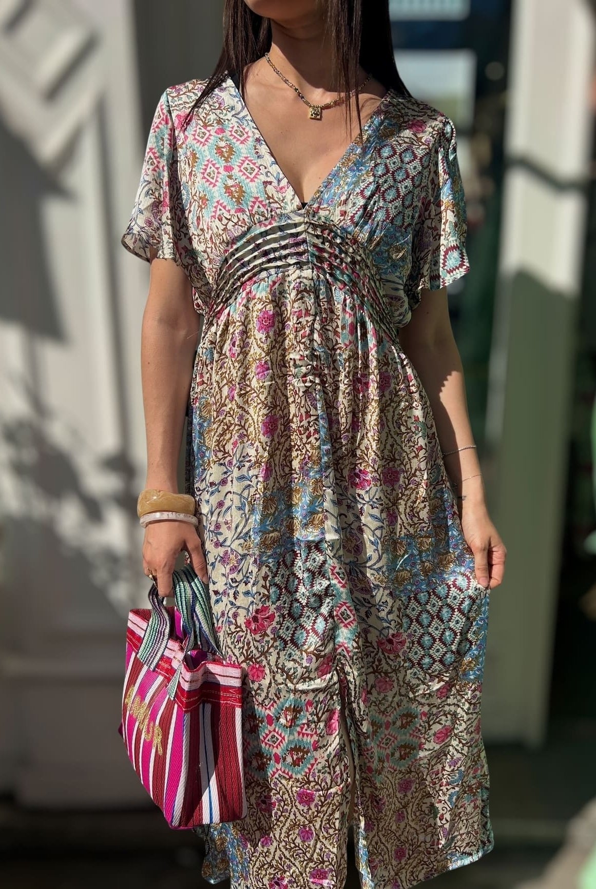 Femme portant une robe en soie imprimé bleu et rose taille empire