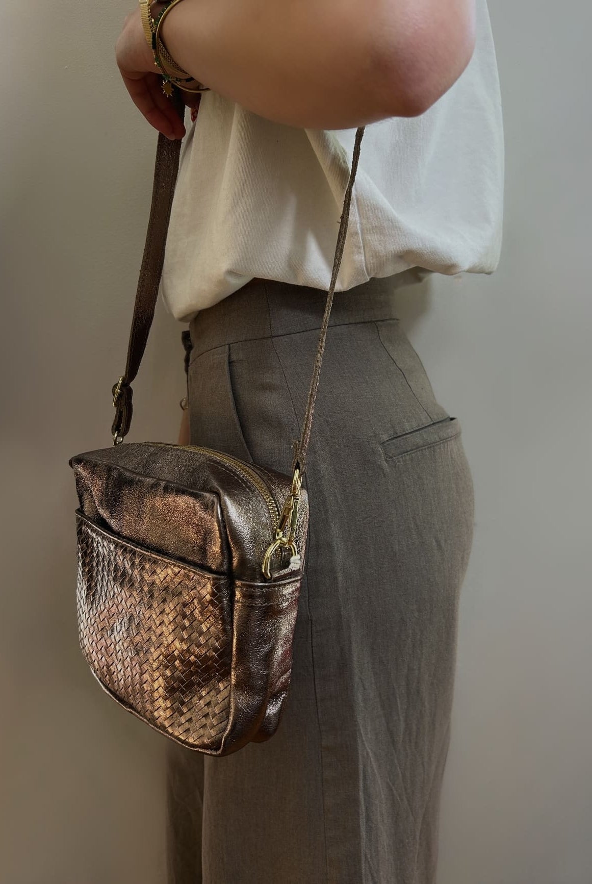 Femme portant le sac taupe métallisé en bandoulière – look élégant et décontracté