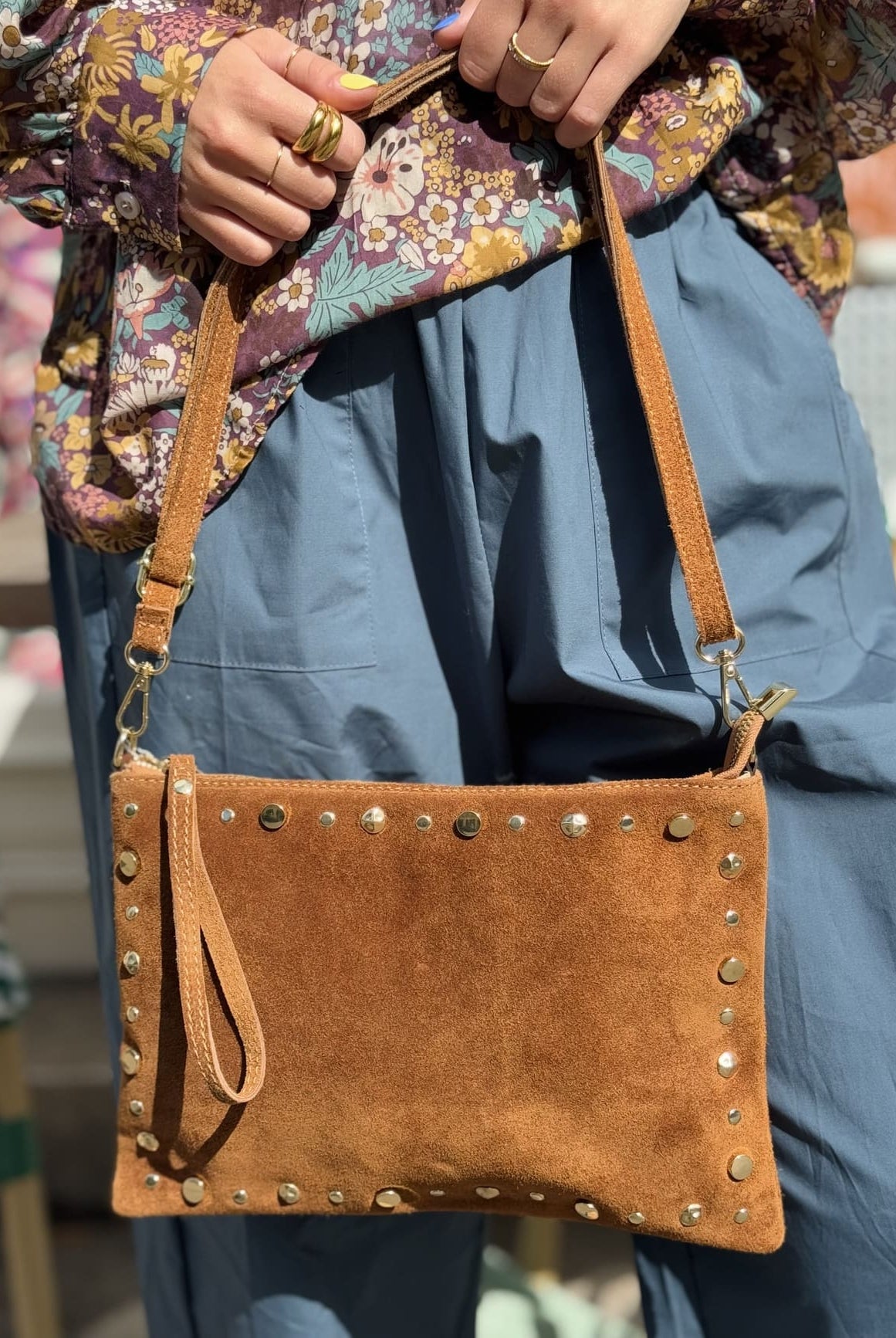gros plan sur un sac en daim pochette en daim clouté
